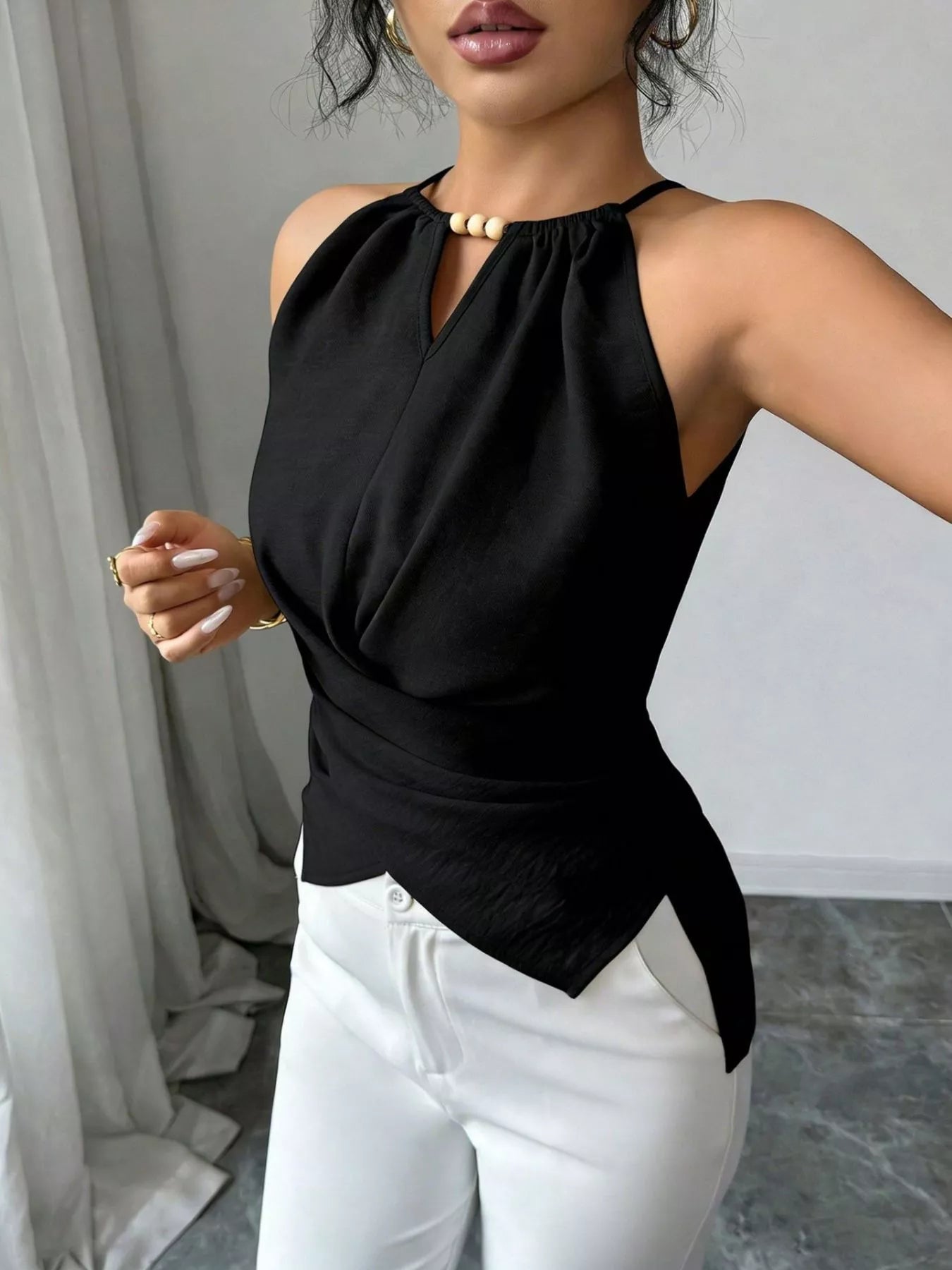 Halter neck crisscross cami top from Trendsi, featuring a stylish design with adjustable straps and a fitted silhouette.