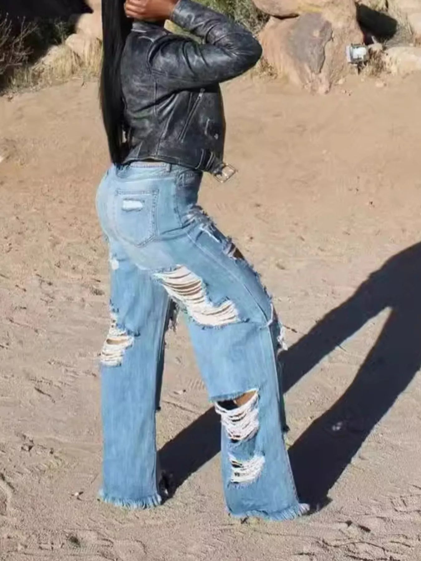 Distressed wide-leg denim jeans from Trendsi, featuring a relaxed fit and frayed details, shown on a model.