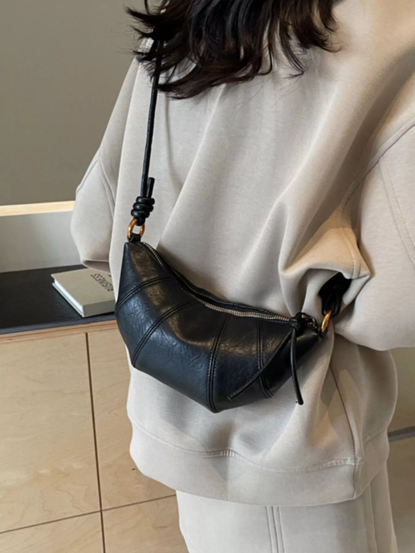 Croissant-shaped crossbody bag from Trendsi, stylish handbag with a unique croissant design and adjustable strap.
