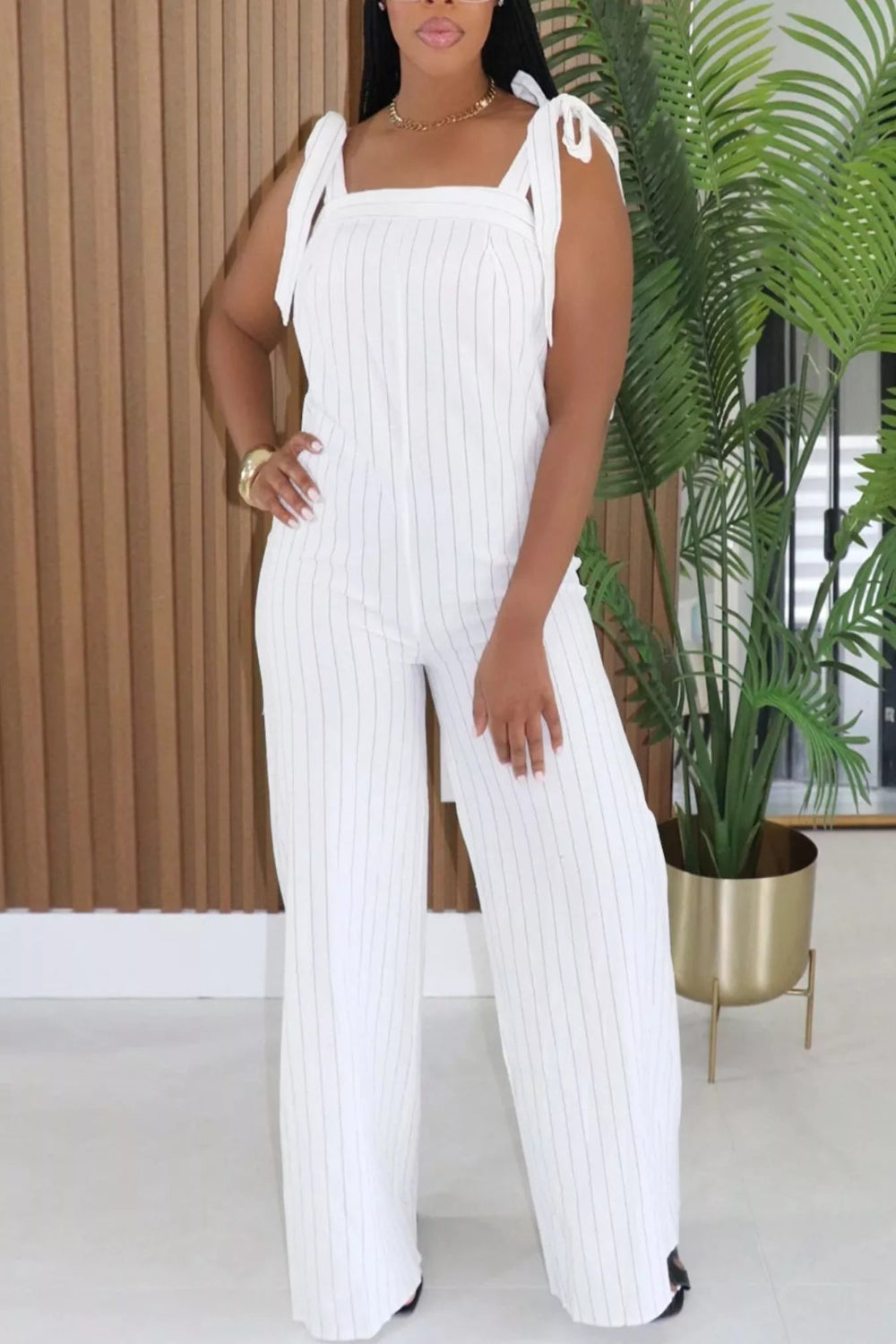 Striped tie-shoulder wide-leg jumpsuit from Trendsi, featuring a stylish design with shoulder straps and flowing wide-leg pants.