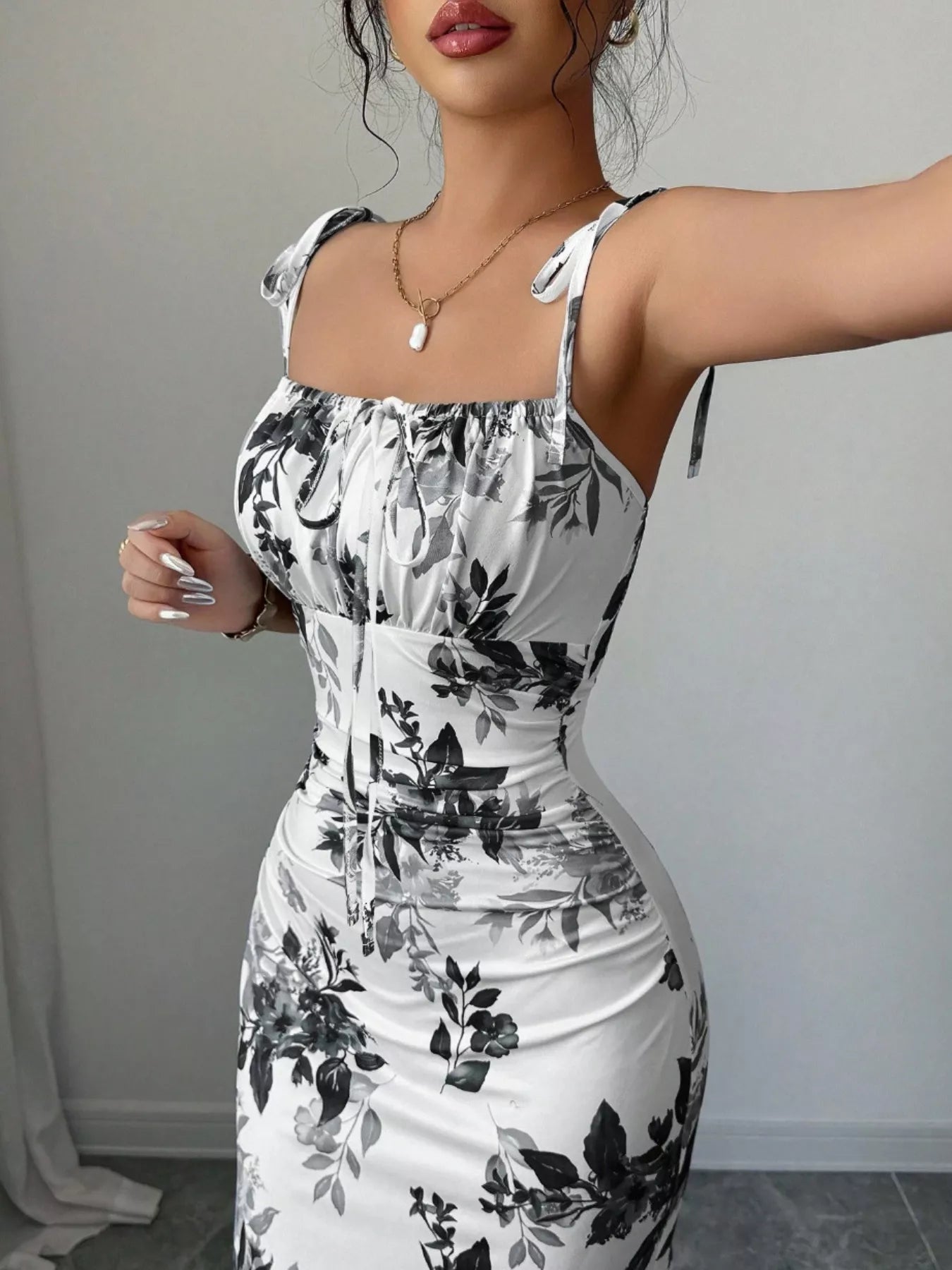 Printed tie strap slit maxi dress by Trendsi featuring a flowing silhouette, adjustable straps, and a stylish slit design.