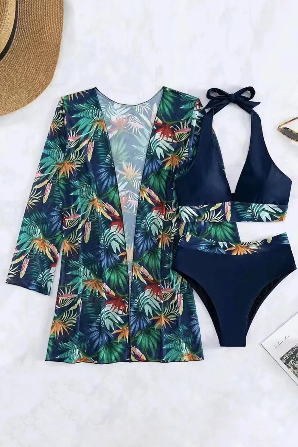 Printed halter neck three-piece swimwear set by Trendsi featuring a stylish bikini top, bottom, and cover-up for beach or pool lounging.