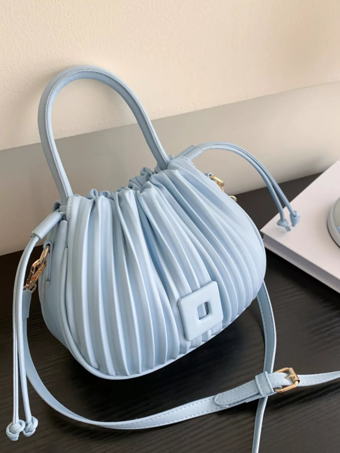 Pleated bucket crossbody handbag by Trendsi featuring a stylish design and adjustable strap, made from durable materials.