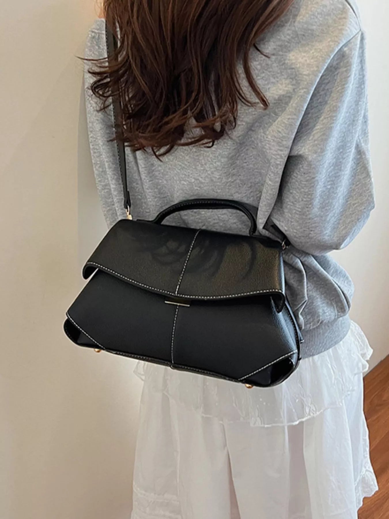 Geometric flap shoulder bag by Trendsi featuring structured design, with a flap closure and stylish shoulder strap.