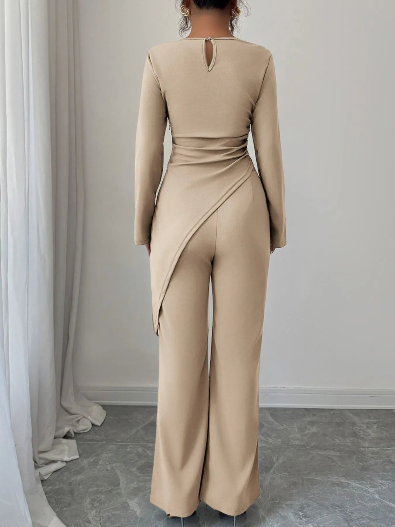 Asymmetric long sleeve top and matching pants set by Trendsi, featuring a modern design and stylish fit in a sleek fabric.