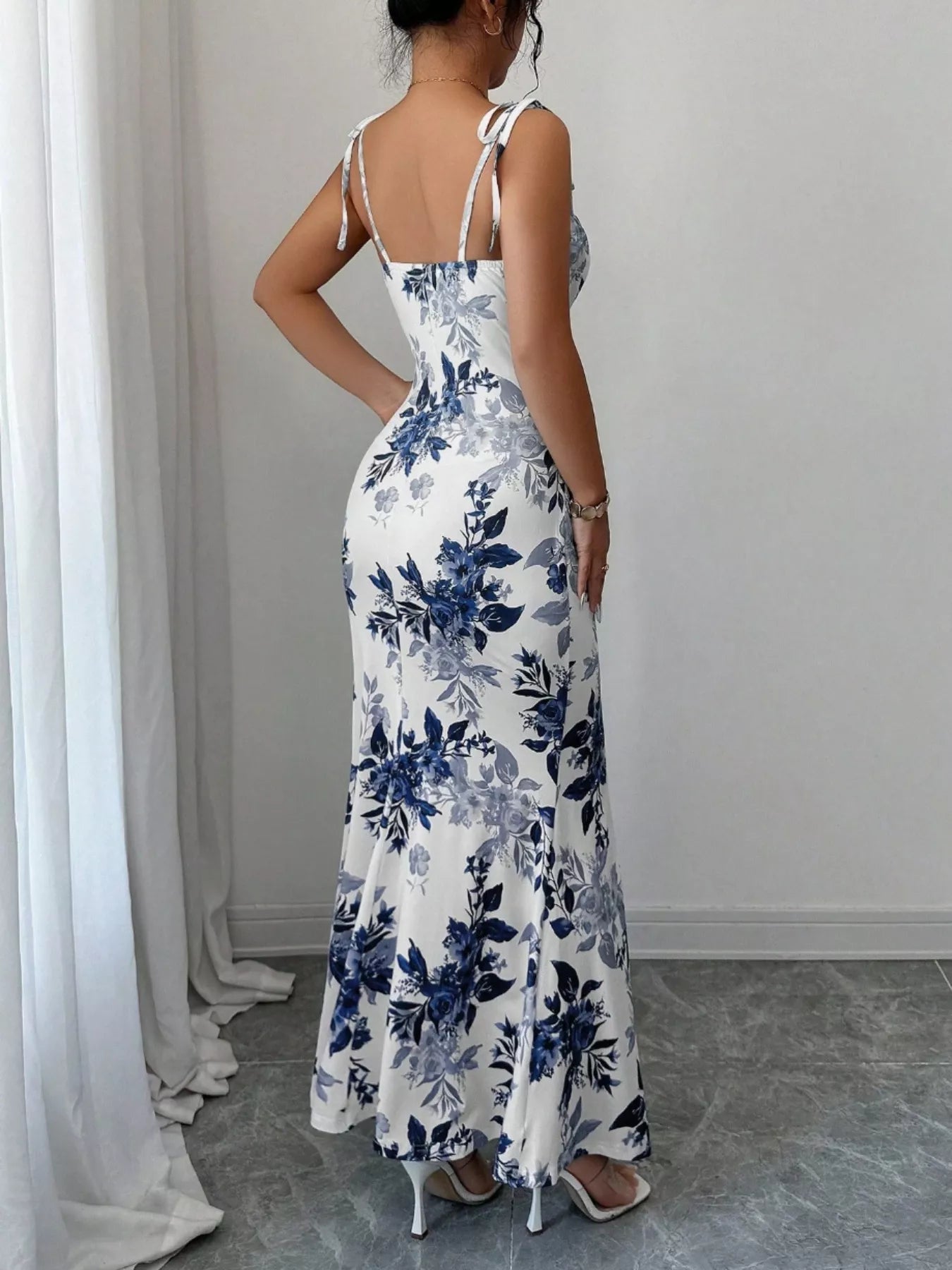 Printed tie-strap slit maxi dress by Trendsi featuring a flowy silhouette, slit detail, and trendy pattern.