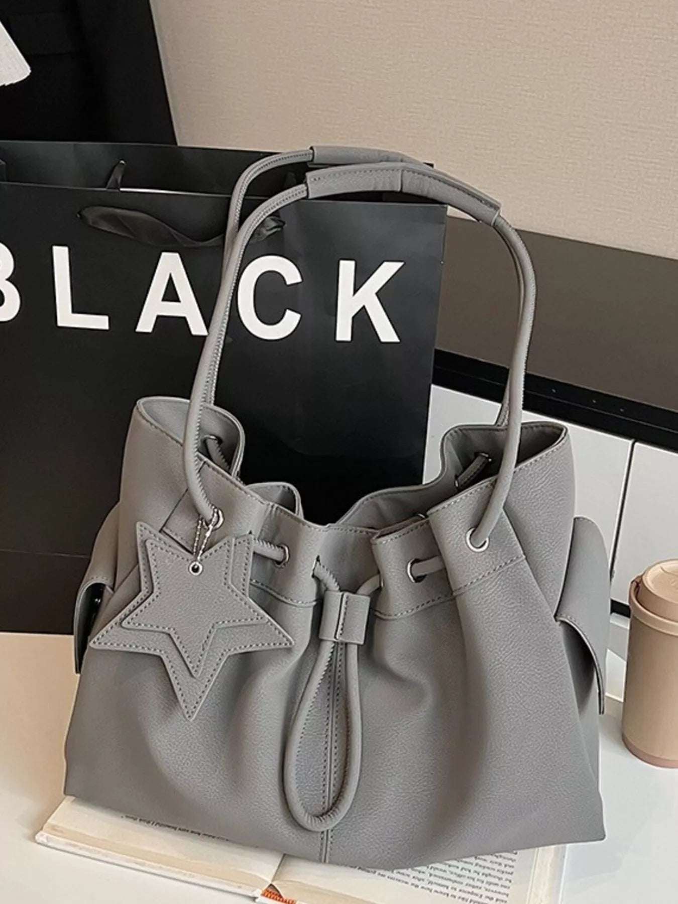 Drawstring shoulder bag by Trendsi featuring a star charm, with a stylish design and compact size, ideal for casual outings.
