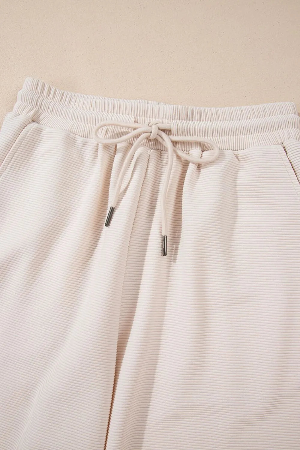 Textured ruffled sleeve zip-up top and wide-leg pants set from Trendsi, featuring stylish design and comfortable fit.