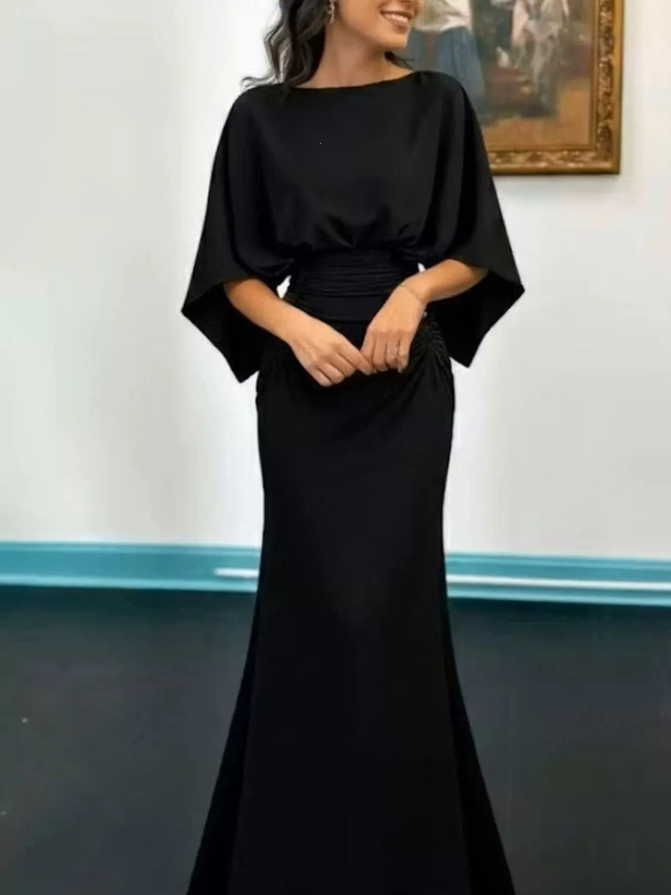 Black batwing sleeve ruched evening dress by Trendsi, showcasing its elegant draped fabric and fitted silhouette.