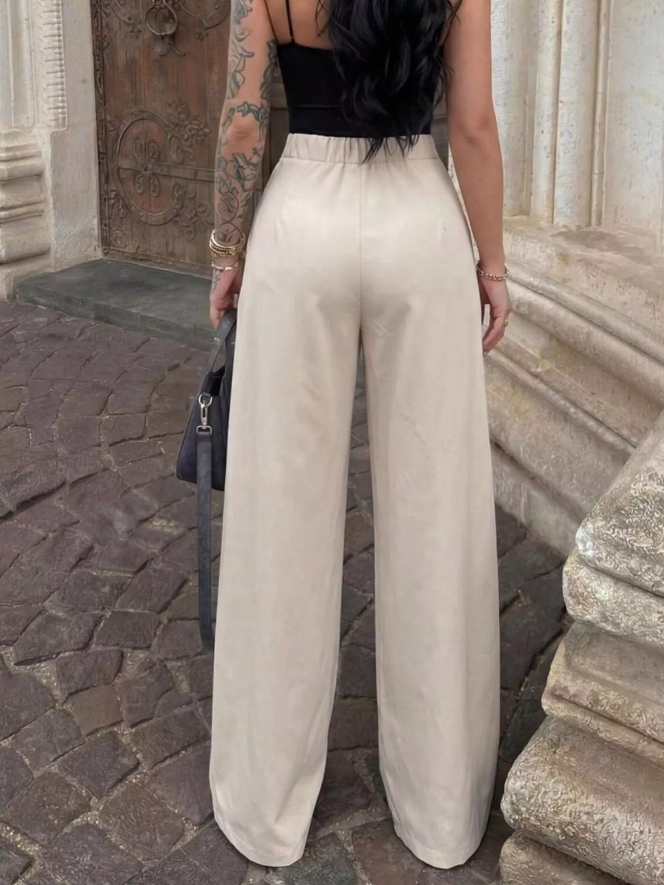 High-waisted pleated wide-leg trousers by Trendsi, showcasing a stylish fit with pleats and flowy wide-leg design.