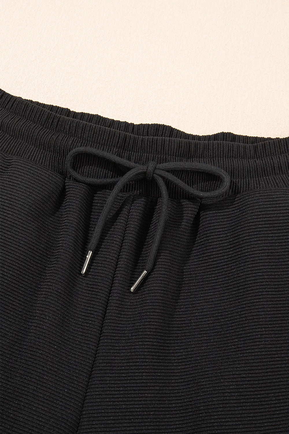 Textured ruffled sleeve zipped top and wide-leg pants set by Trendsi, featuring a stylish, coordinated outfit with textured fabric.