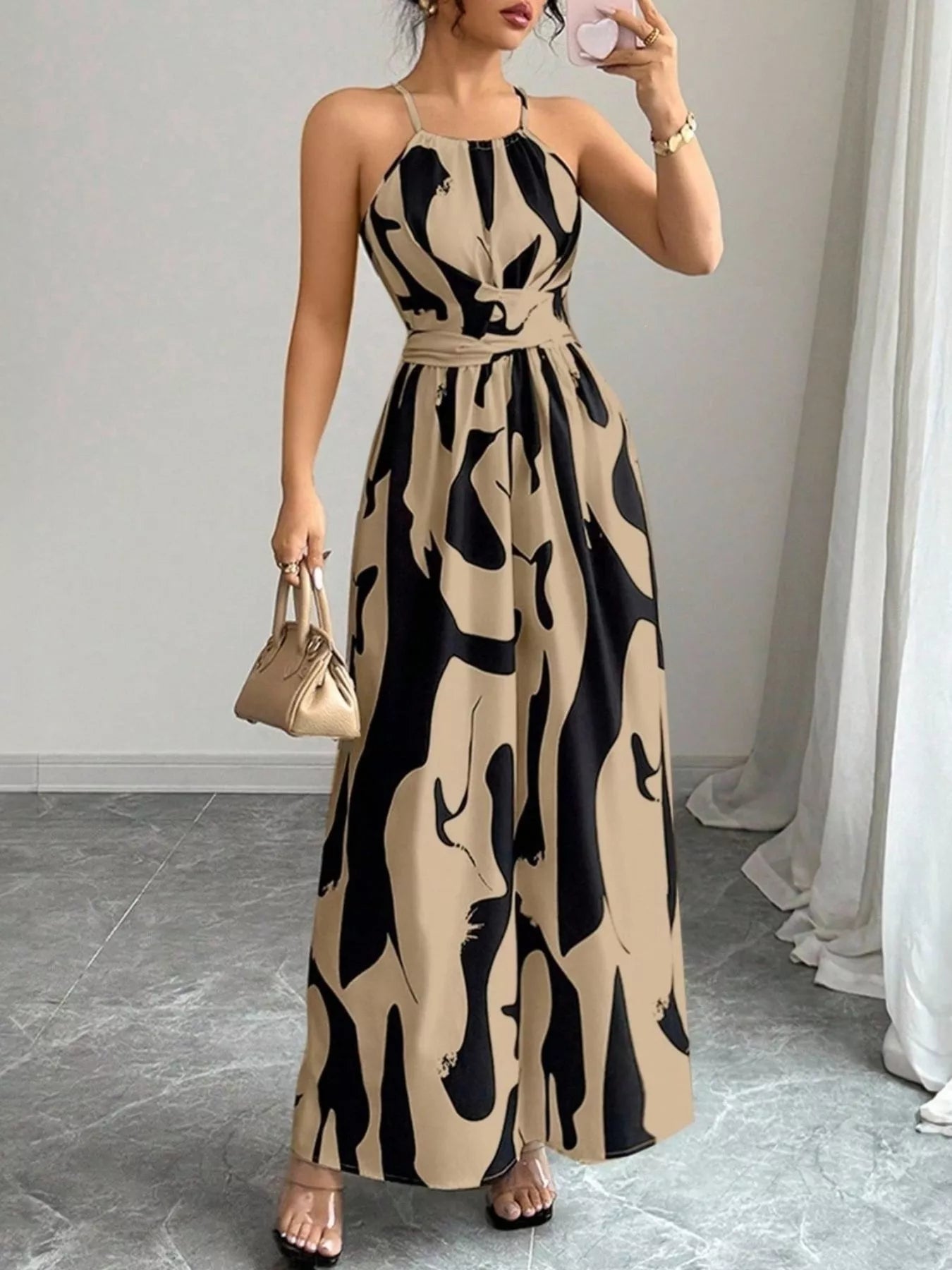 Abstract print halter neck maxi dress from Trendsi featuring a flowing silhouette and vibrant artwork design.