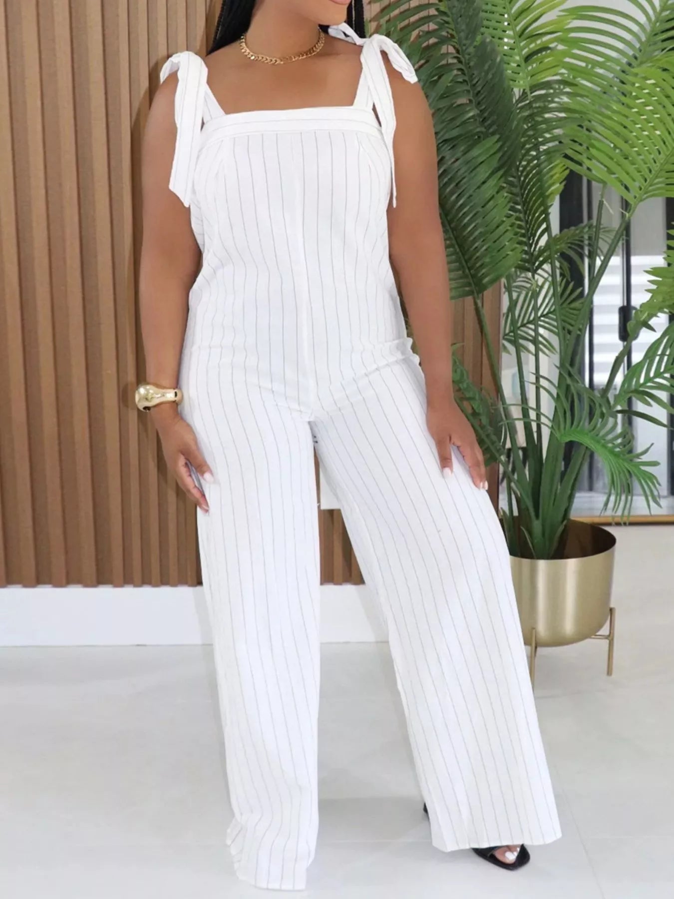 Striped tie-shoulder wide-leg jumpsuit by Trendsi featuring a stylish design and relaxed fit, perfect for casual or chic occasions.