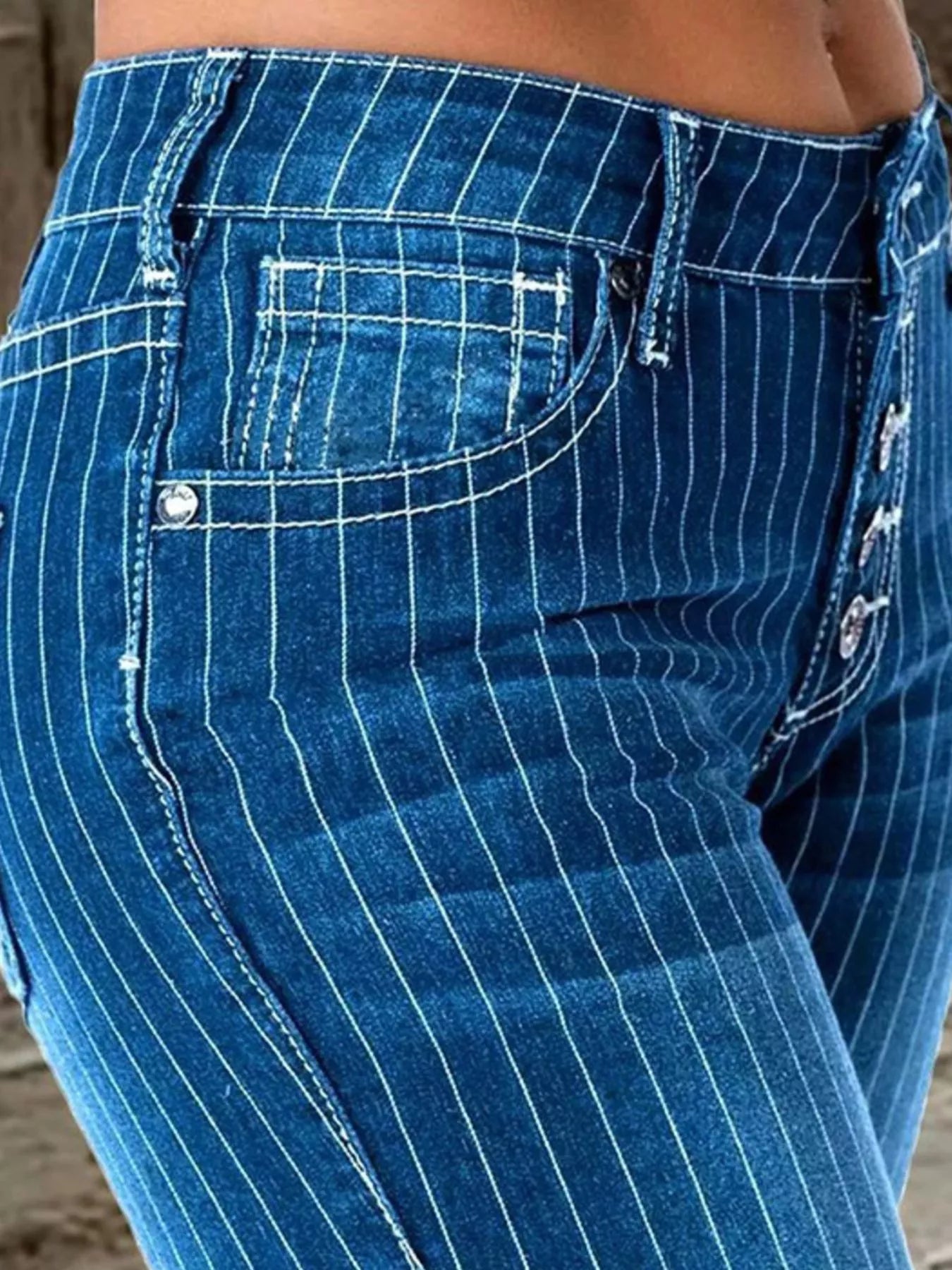 Striped button fly flare denim jeans by Trendsi, featuring high waist, vibrant stripes, and wide-leg style for a trendy look.