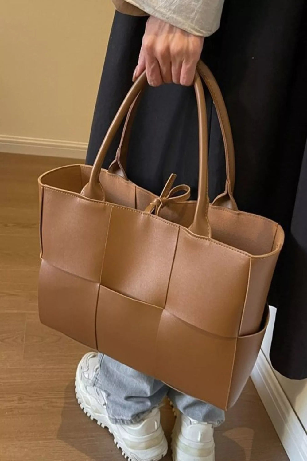 Woven leather tote handbag with sturdy handles, stylish and spacious, ideal for everyday use and casual outings.