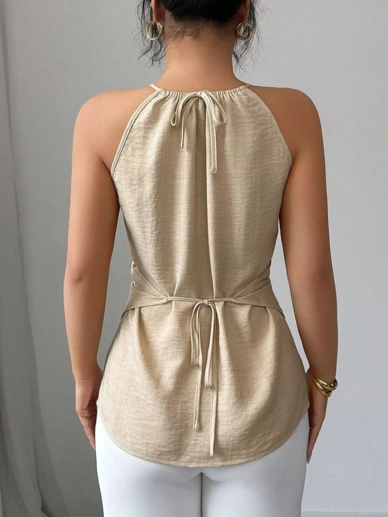 Black halter neck crisscross cami top from Trendsi, sleeveless blouse with stylish front design and adjustable straps.