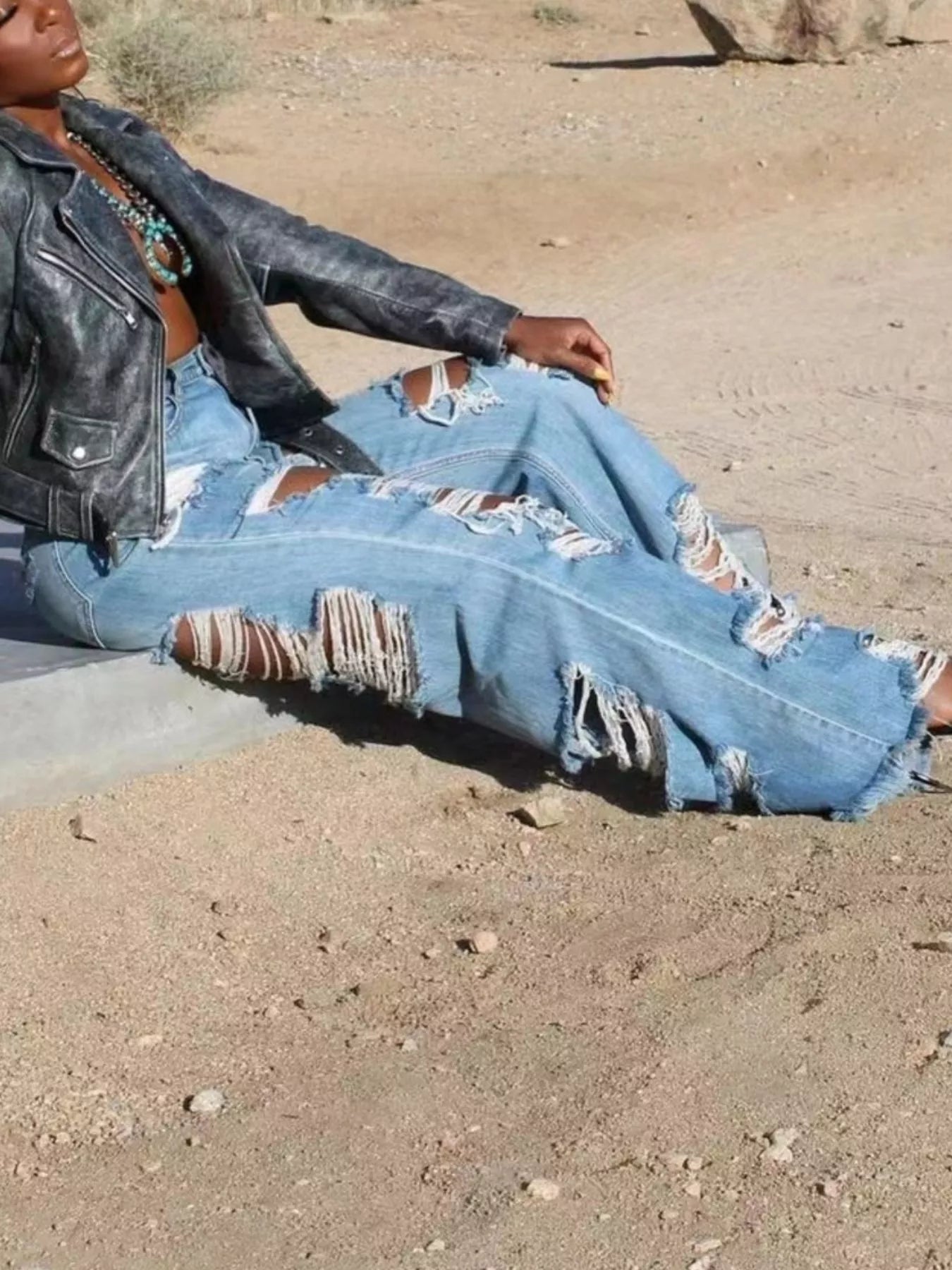 Distressed wide-leg denim jeans from Trendsi with ripped details and a relaxed fit, displayed on a neutral background.