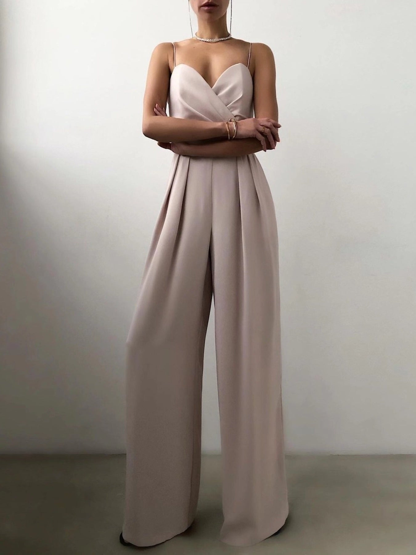 Cream spaghetti strap wide leg jumpsuit by Trendsi, featuring a flowy silhouette and adjustable straps.