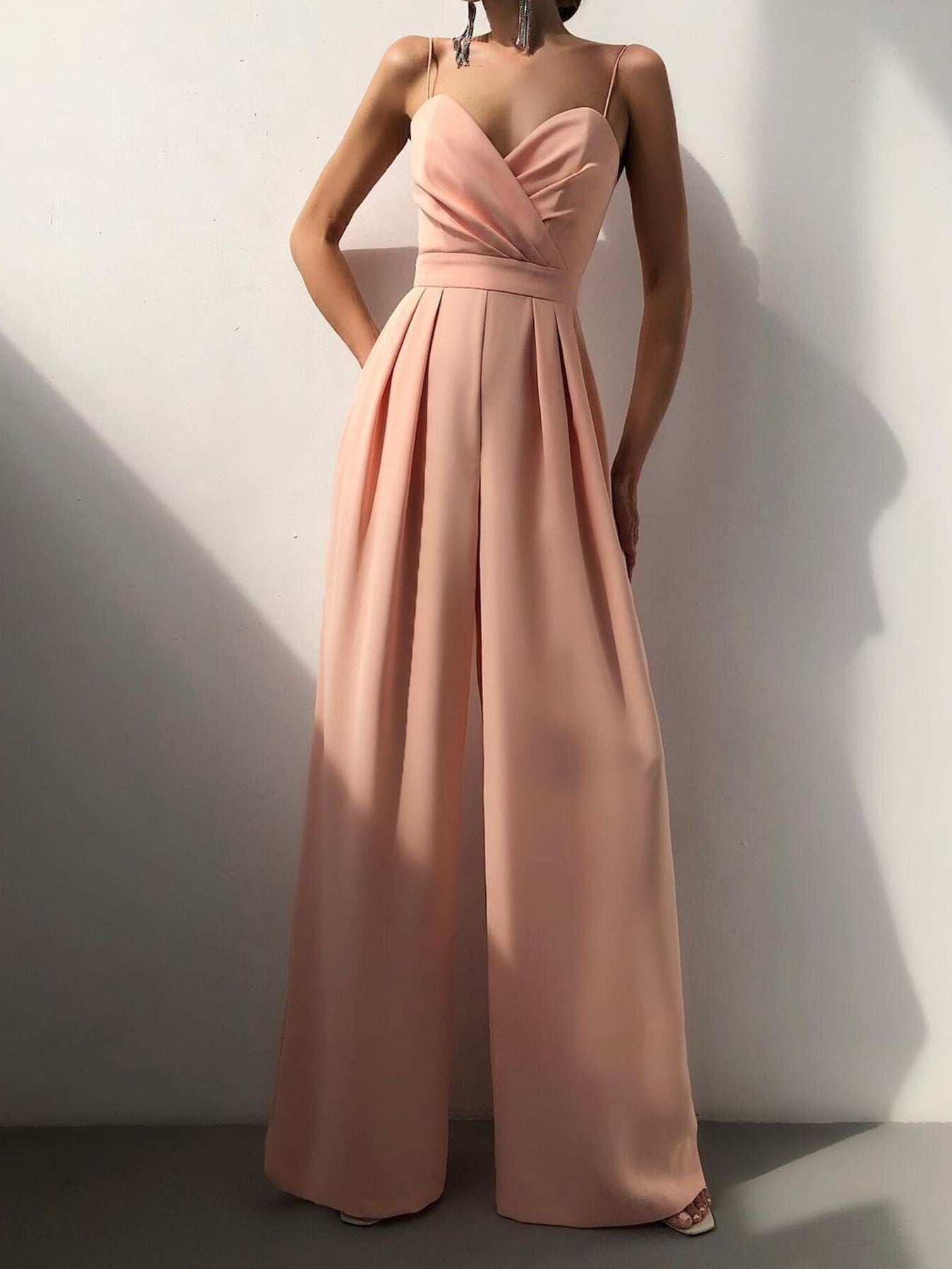 Black spaghetti strap wide-leg jumpsuit from Trendsi, featuring a fitted bodice and flowy pant legs, perfect for casual or dressy occasions.