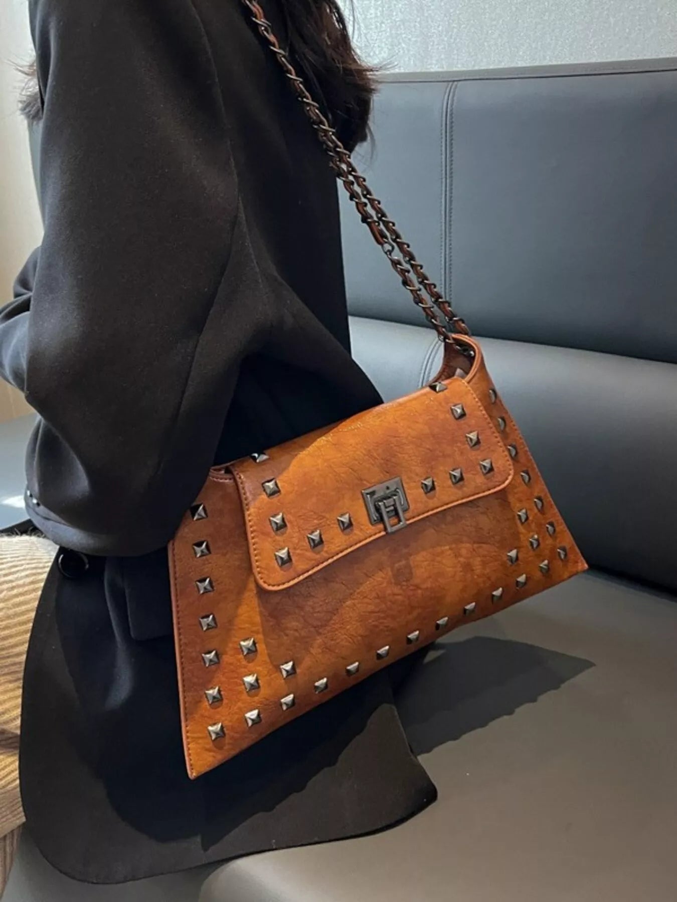Black studded flap chain shoulder handbag from Trendsi, featuring a sleek design with metal chain strap and multiple compartments.