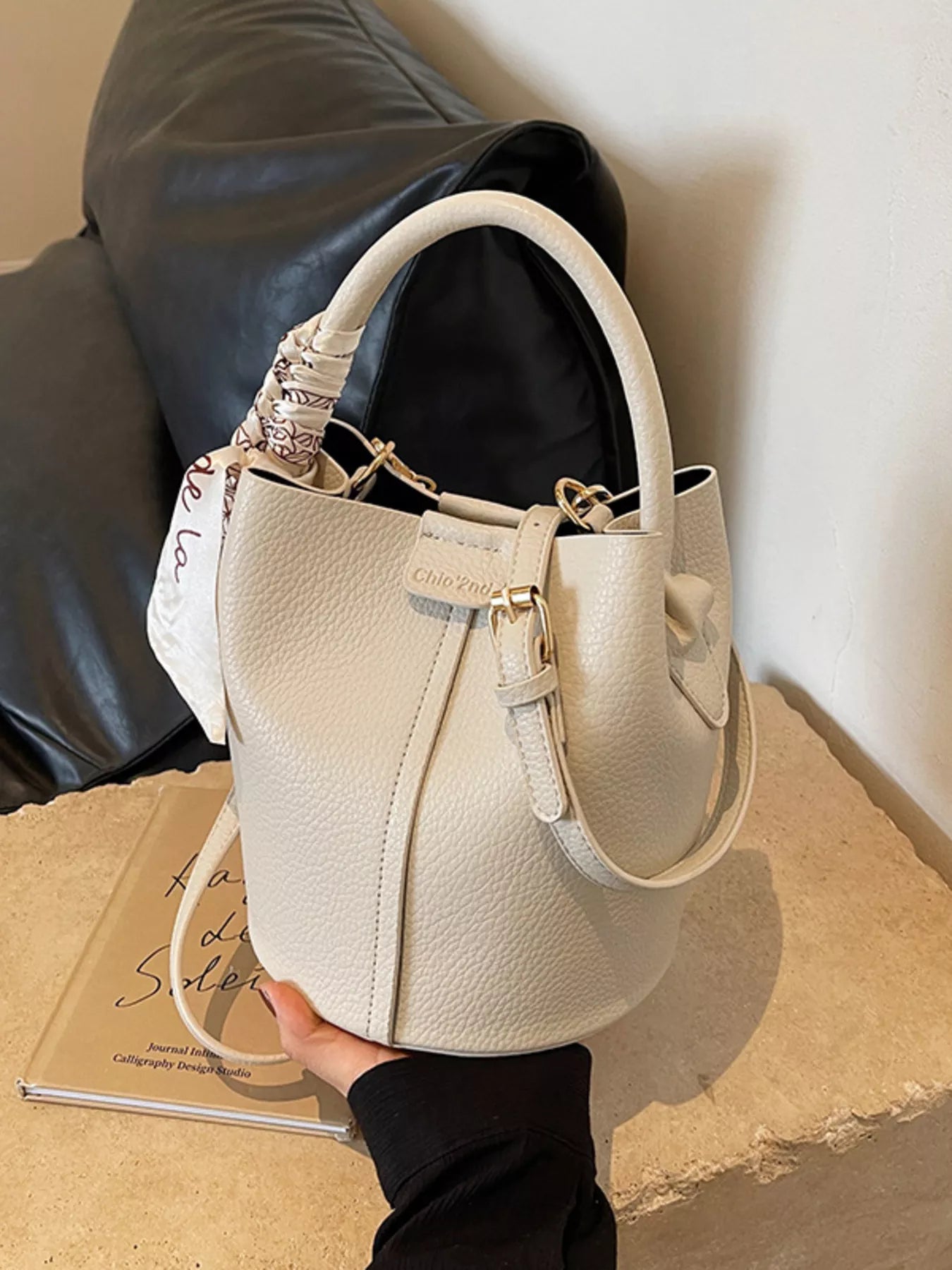 Leather bucket crossbody handbag by Trendsi, featuring a tan leather exterior with adjustable strap and minimalist design.
