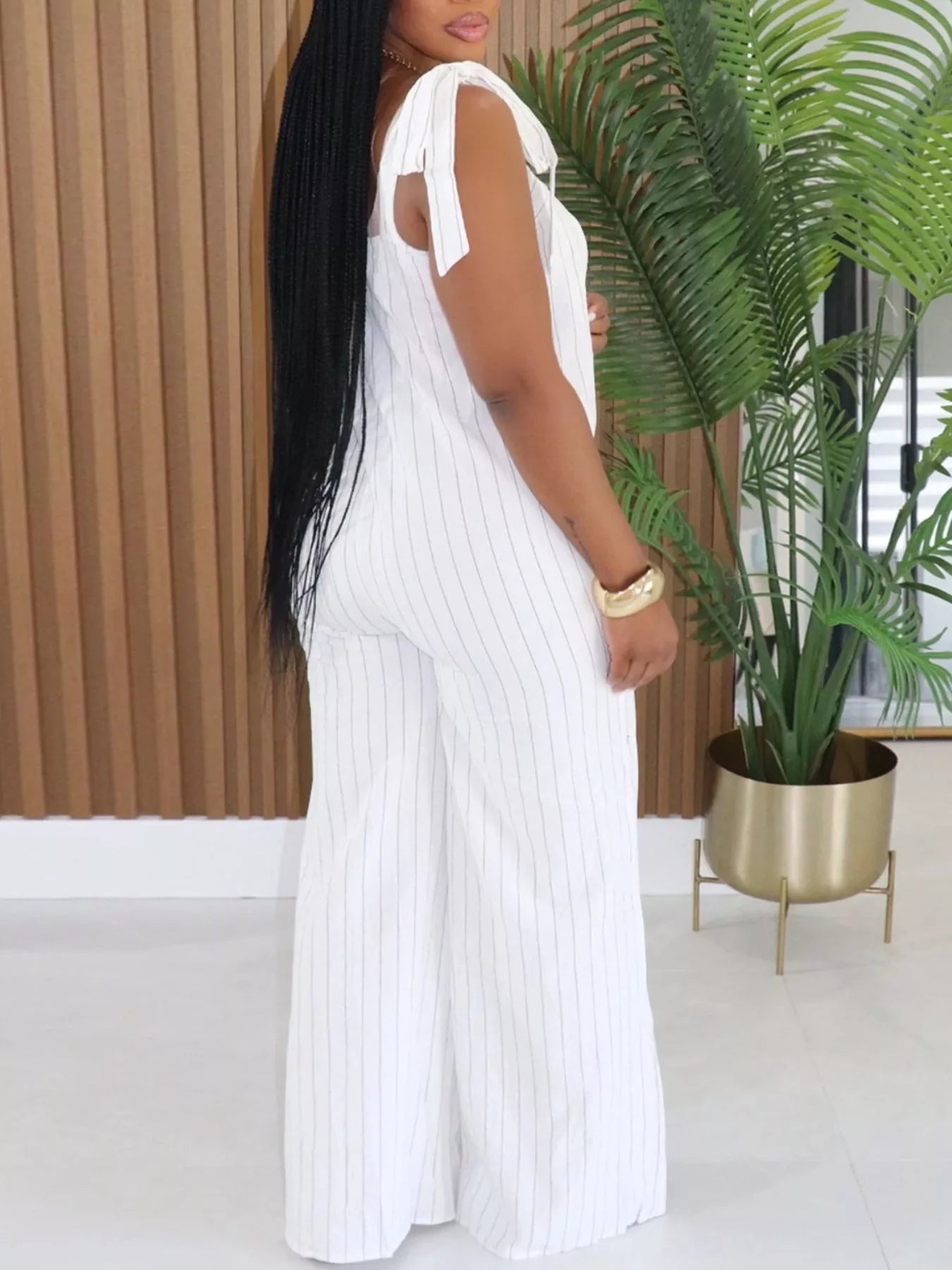 Striped tie-shoulder wide-leg jumpsuit by Trendsi, featuring a stylish design with shoulder ties and flowing wide-leg pants.
