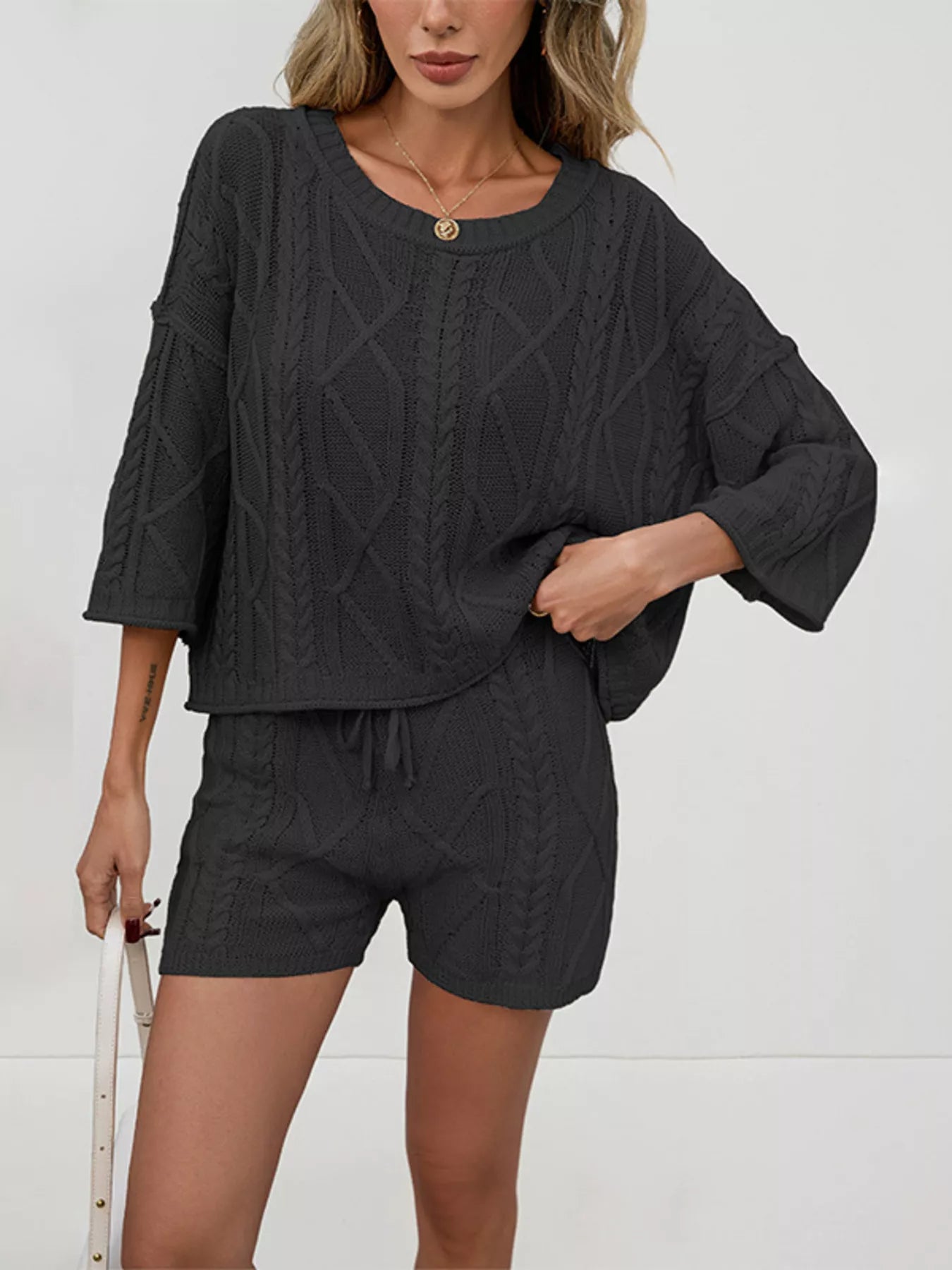 Cable knit round neck top and shorts sweater set by Trendsi, cozy knit fabric, featuring a matching top and shorts for casual wear.