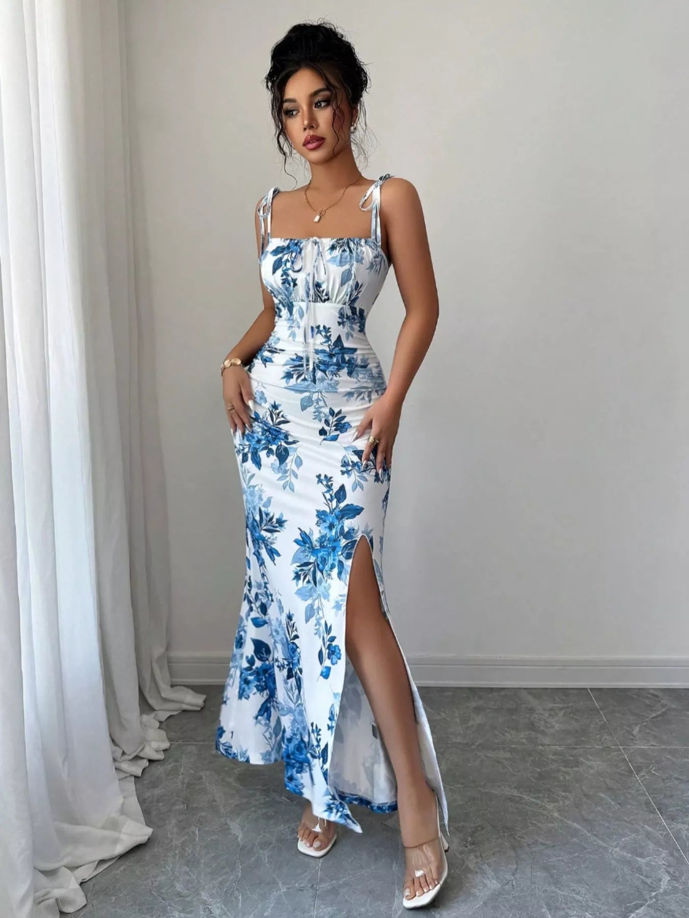 Printed tie strap slit maxi dress from Trendsi featuring a flowing silhouette, adjustable straps, and a stylish slit design.