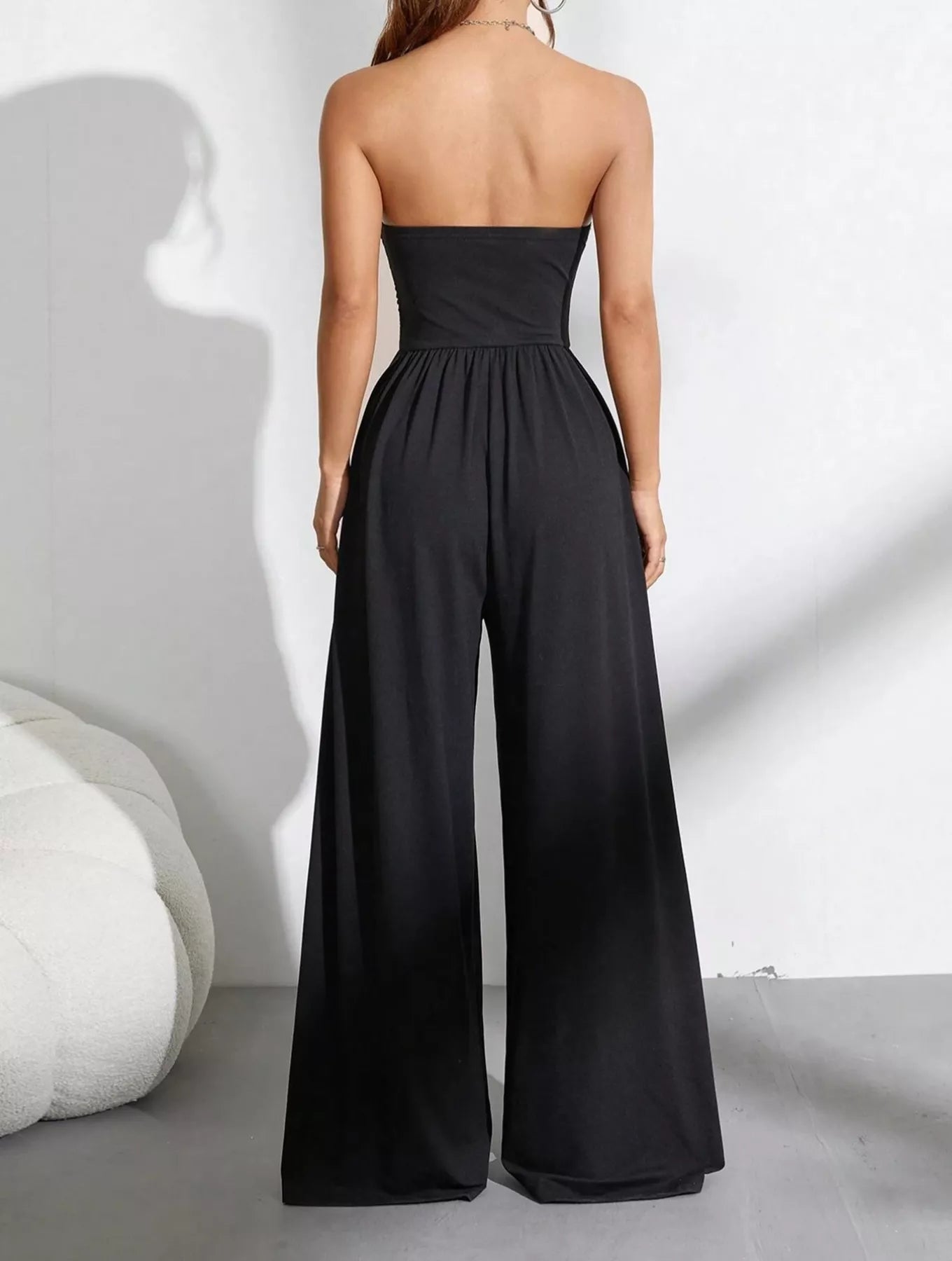 Trendsi effortless chic tube top wide-leg jumpsuit worn by a model, featuring a fitted tube top and flowing wide-leg pants.