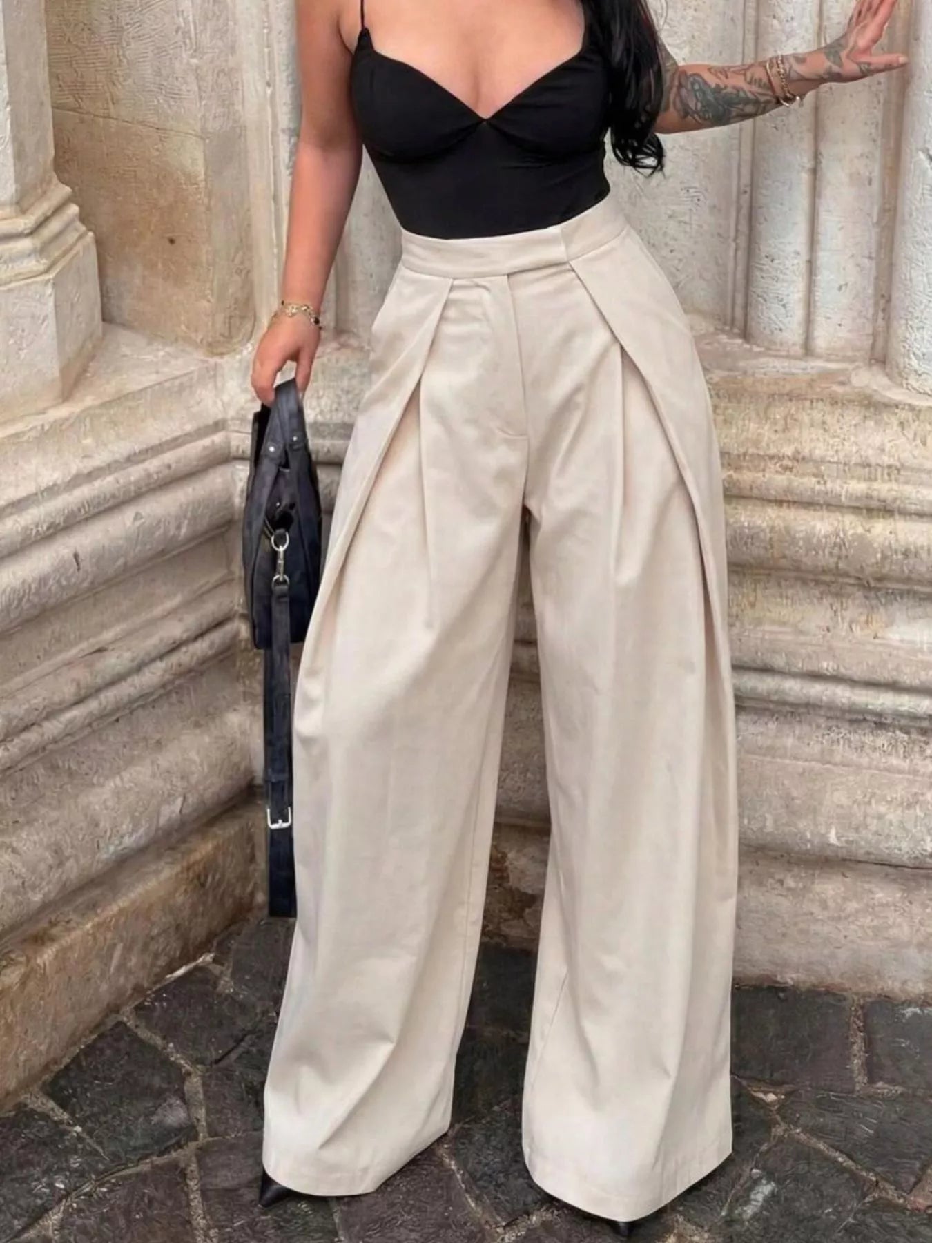 High-waisted pleated wide-leg trousers by Trendsi, featuring flowy fabric and tailored fit, styled for a chic, modern look.
