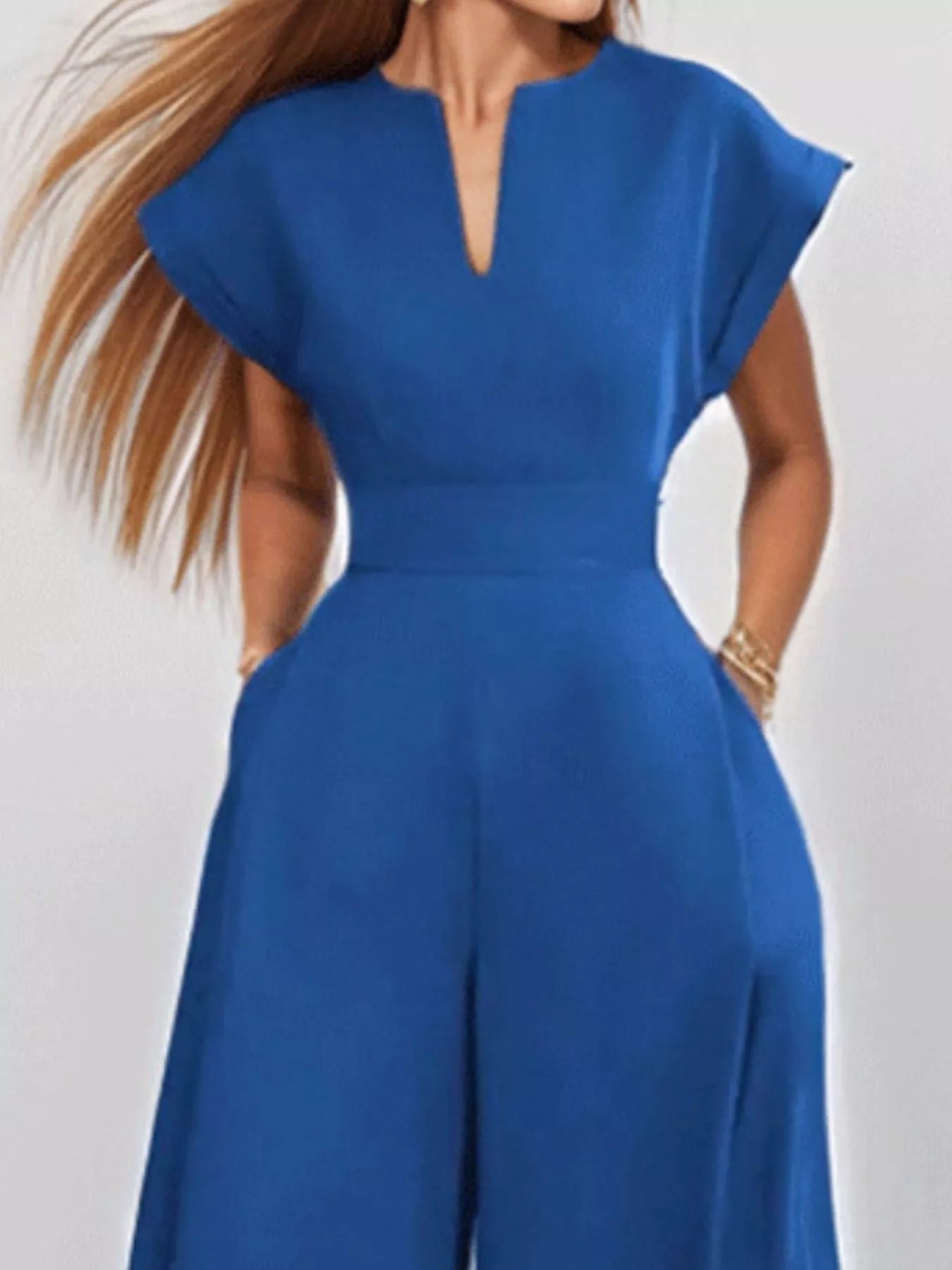 Notched wide-leg jumpsuit by Trendsi featuring a stylish design, sleeveless cut, and relaxed fit on a mannequin.
