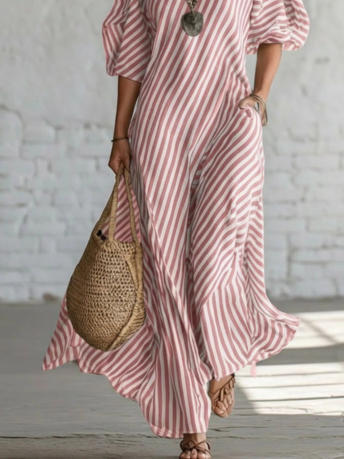Striped one-shoulder maxi dress from Trendsi featuring bold horizontal stripes and flowing fabric on a model.
