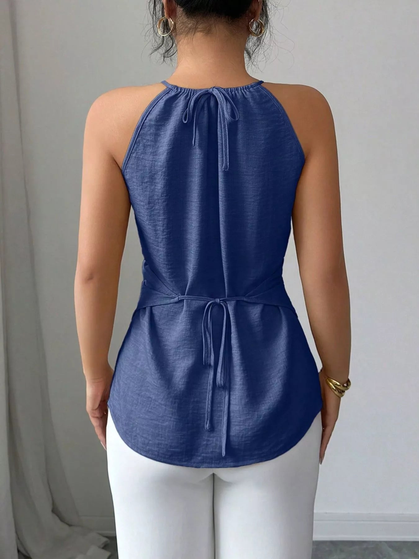 Black halter neck crisscross cami top by Trendsi, featuring a stylish neckline and slim fit, perfect for casual or dressy outfits.
