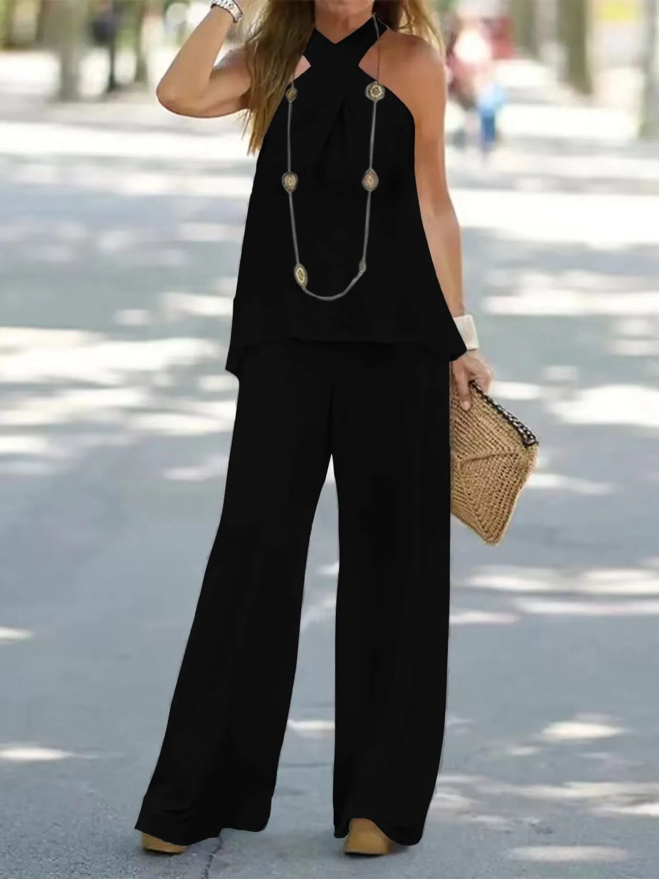 Trendsi halter top and wide-leg pants set displayed on a model, featuring a stylish matching ensemble with a fitted halter top and flowy pants.