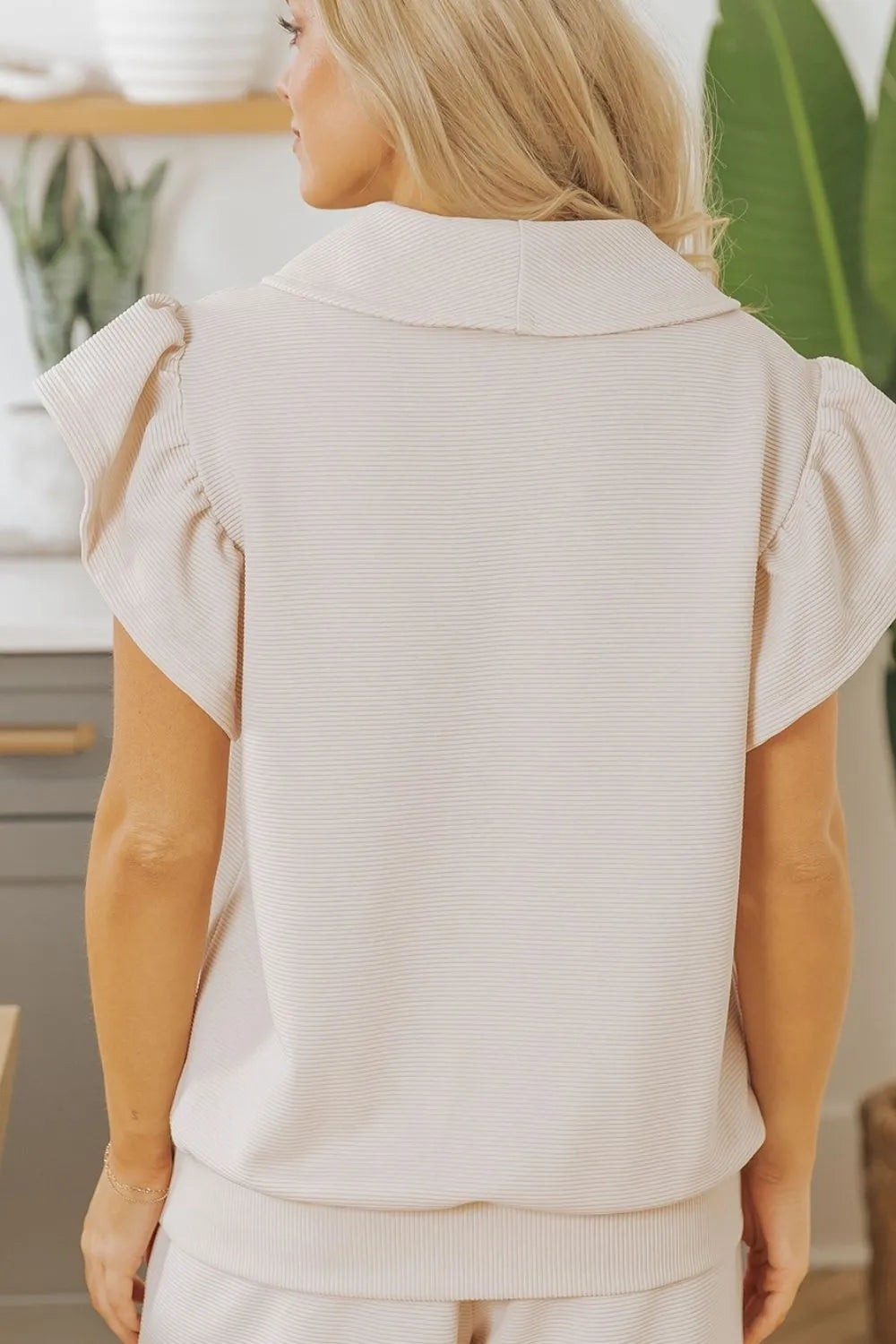 Textured ruffled sleeve zipped top and wide-leg pants set by Trendsi, shown with the stylish matching outfit on a mannequin.