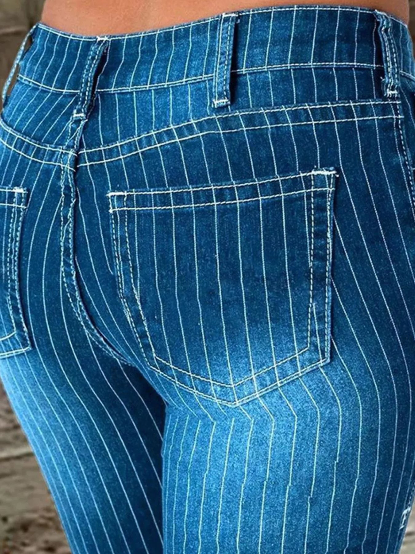 Striped button fly flare jeans made of denim by Trendsi, featuring bold vertical stripes and a high-waist fit.