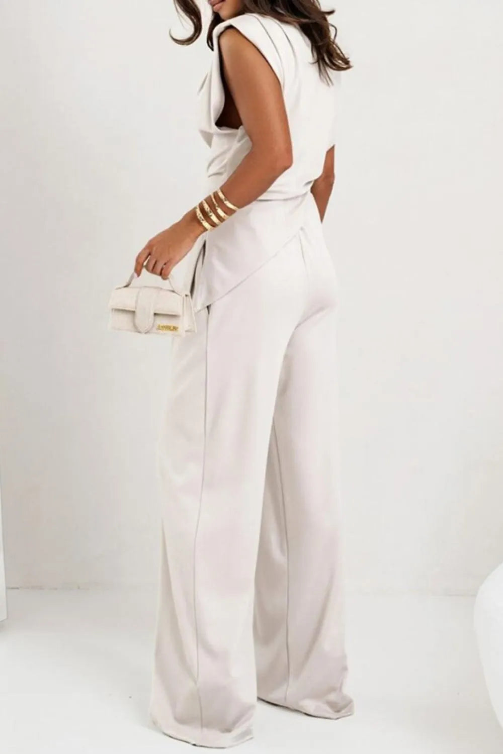 Draped sleeveless asymmetric top and matching pants set by Trendsi, featuring modern design and stylish fit.