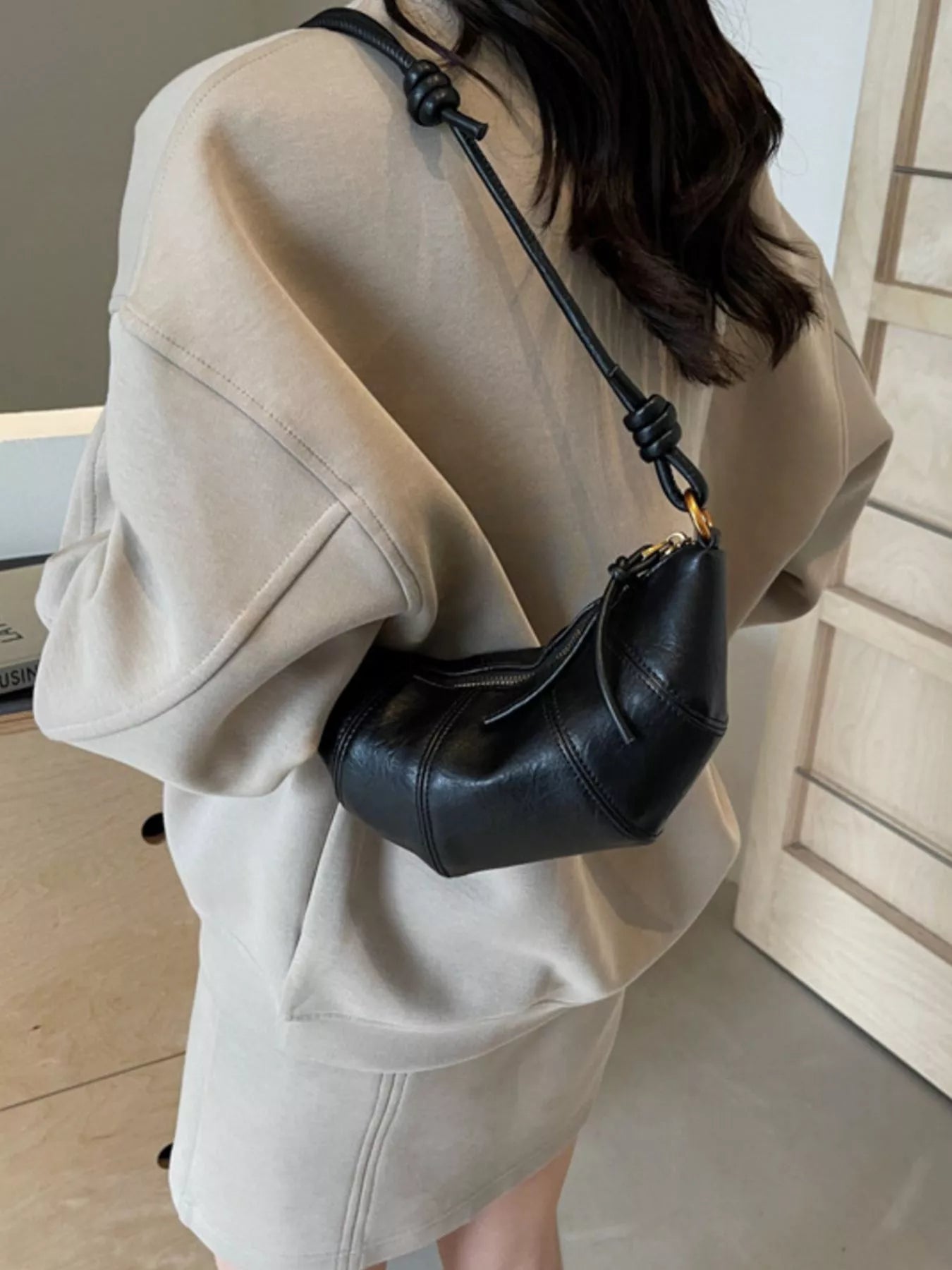 Croissant-shaped crossbody handbag in beige with a gold chain strap, trendy fashion accessory from Trendsi.