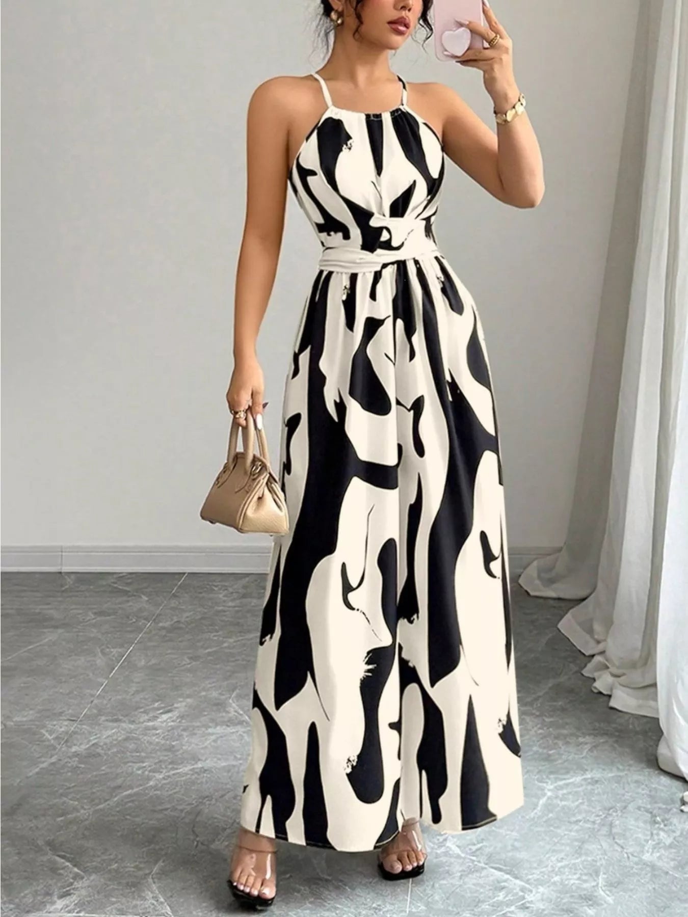 Abstract print halter neck maxi dress from Trendsi featuring flowing fabric and a stylish, modern design.