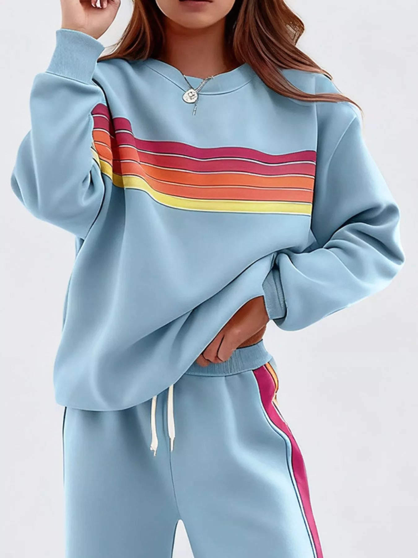 Striped round neck sweatshirt and pants set from Trendsi, casual loungewear with bold stripe pattern and comfortable fit.