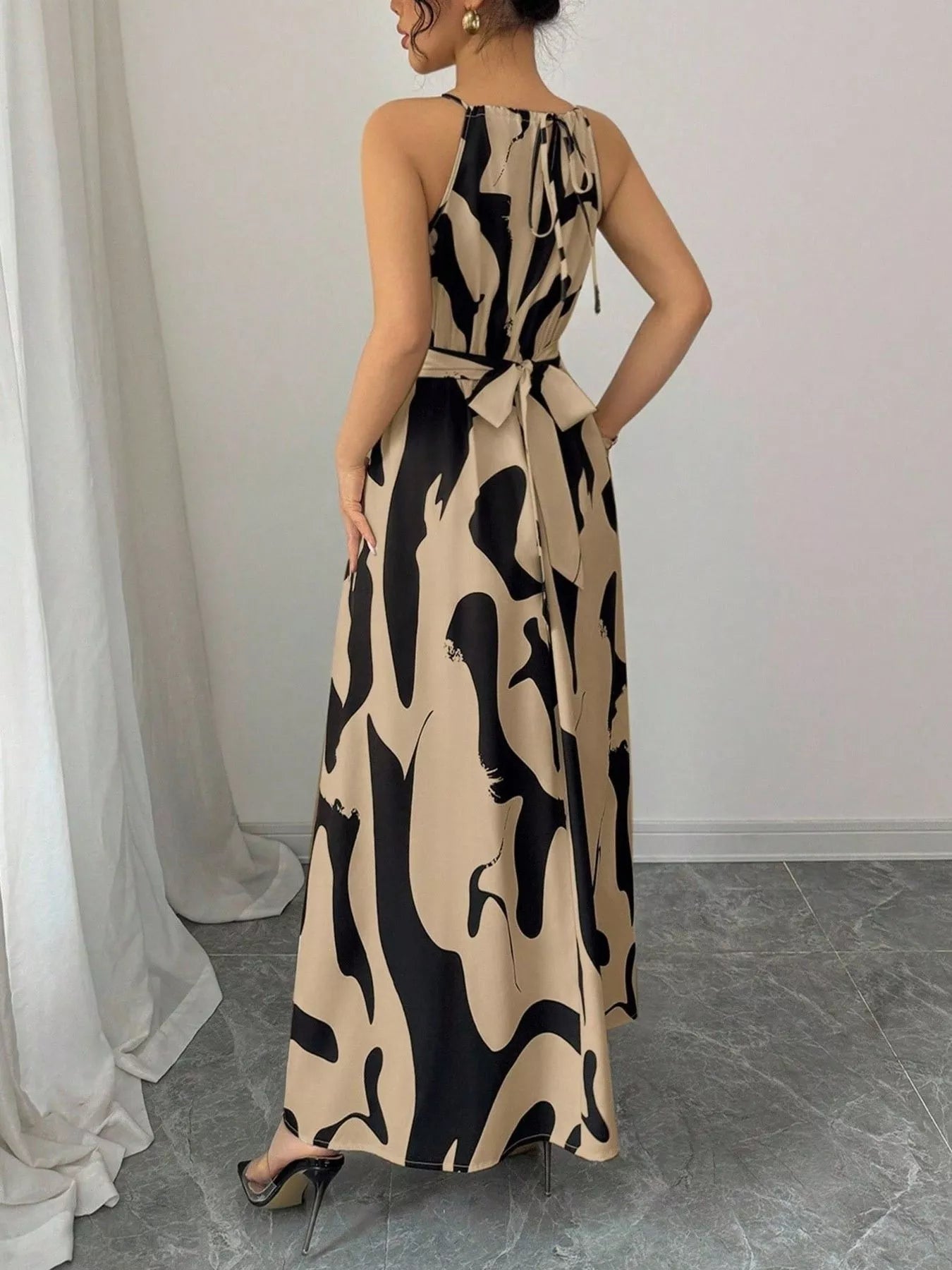 Abstract print halter neck maxi dress from Trendsi featuring a flowing silhouette and vibrant pattern, perfect for summer occasions.