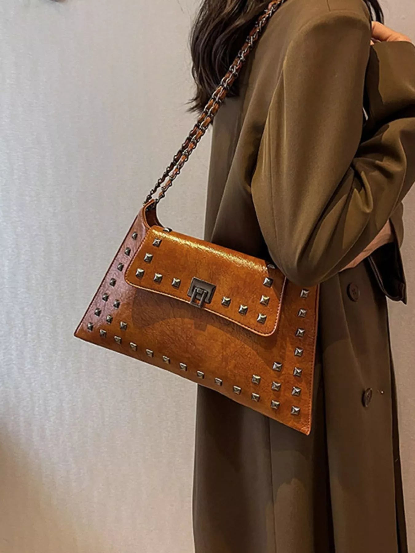 Studded flap chain shoulder bag from Trendsi featuring a stylish design with chain strap and textured exterior.