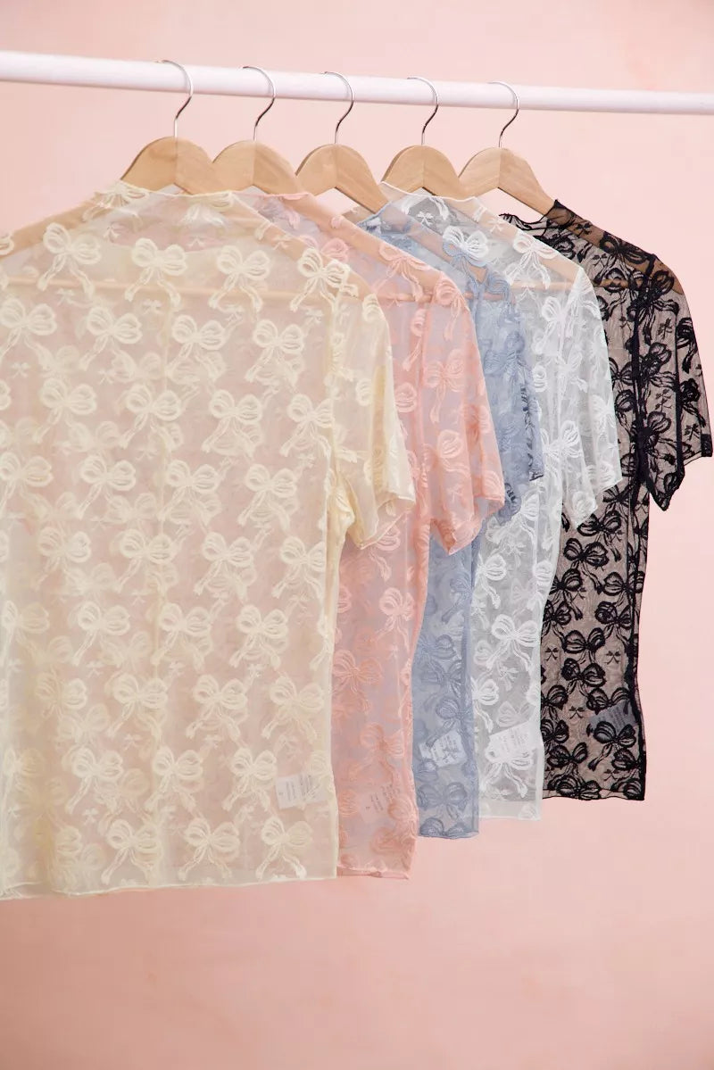 Trendsi high neckline short sleeve mesh top with bow pattern, stylish blouse featuring a fitted design and elegant details.