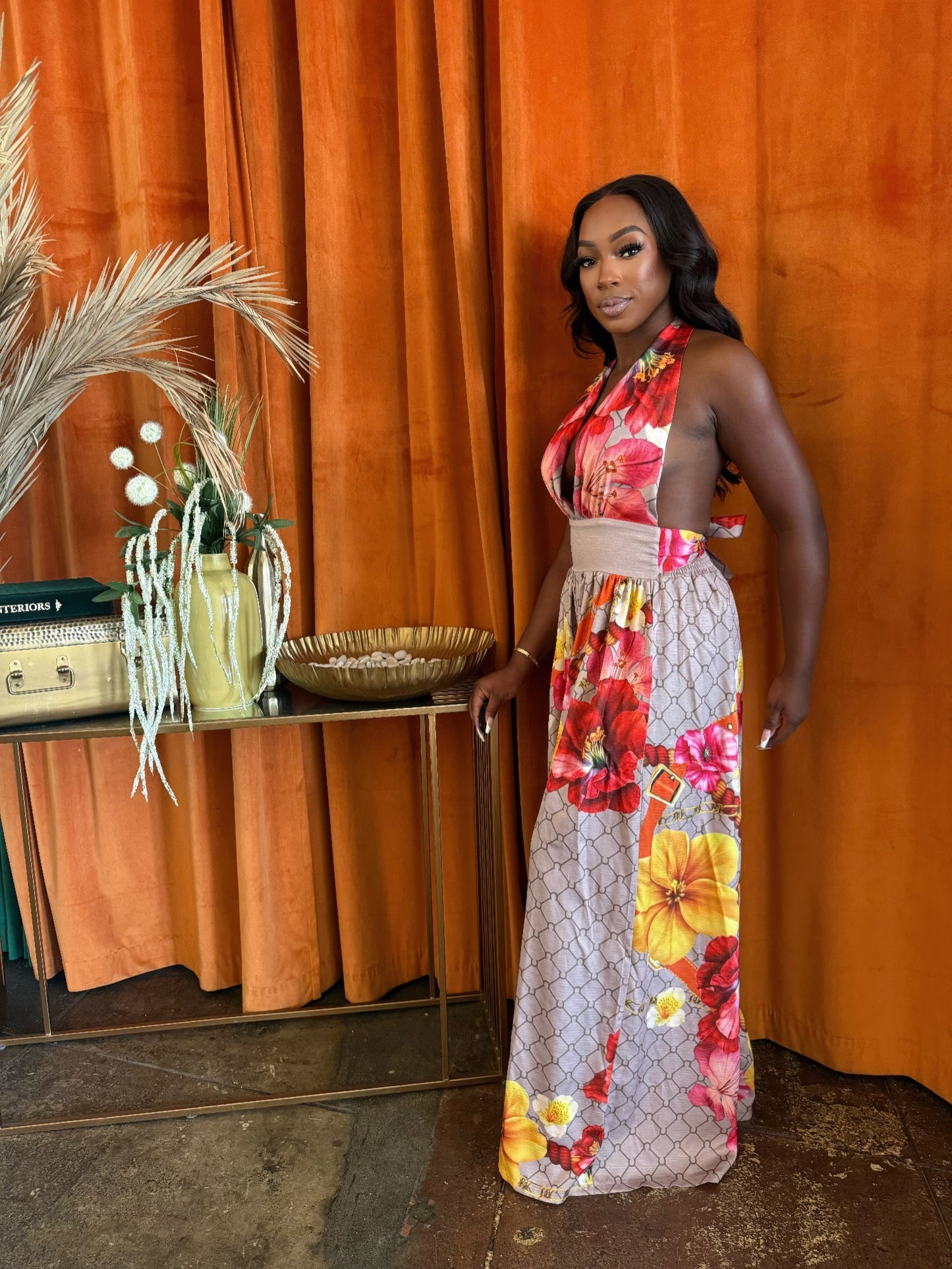 Toshe Women's Fashions Paradise Bloom jumpsuit featuring a floral print and sleeveless design, displayed on a hanger.