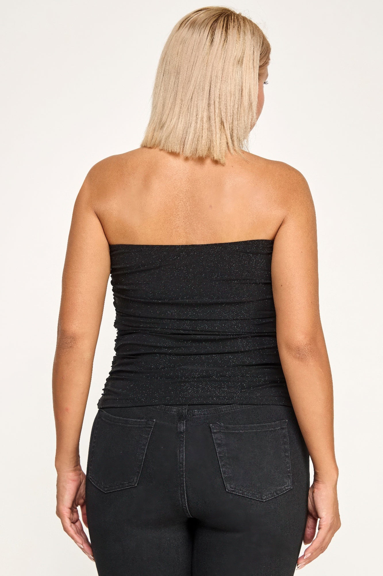 Shimmering strapless glitter bandeau top from Toshe Women's Fashions, showcasing its sparkling fabric and snug fit.