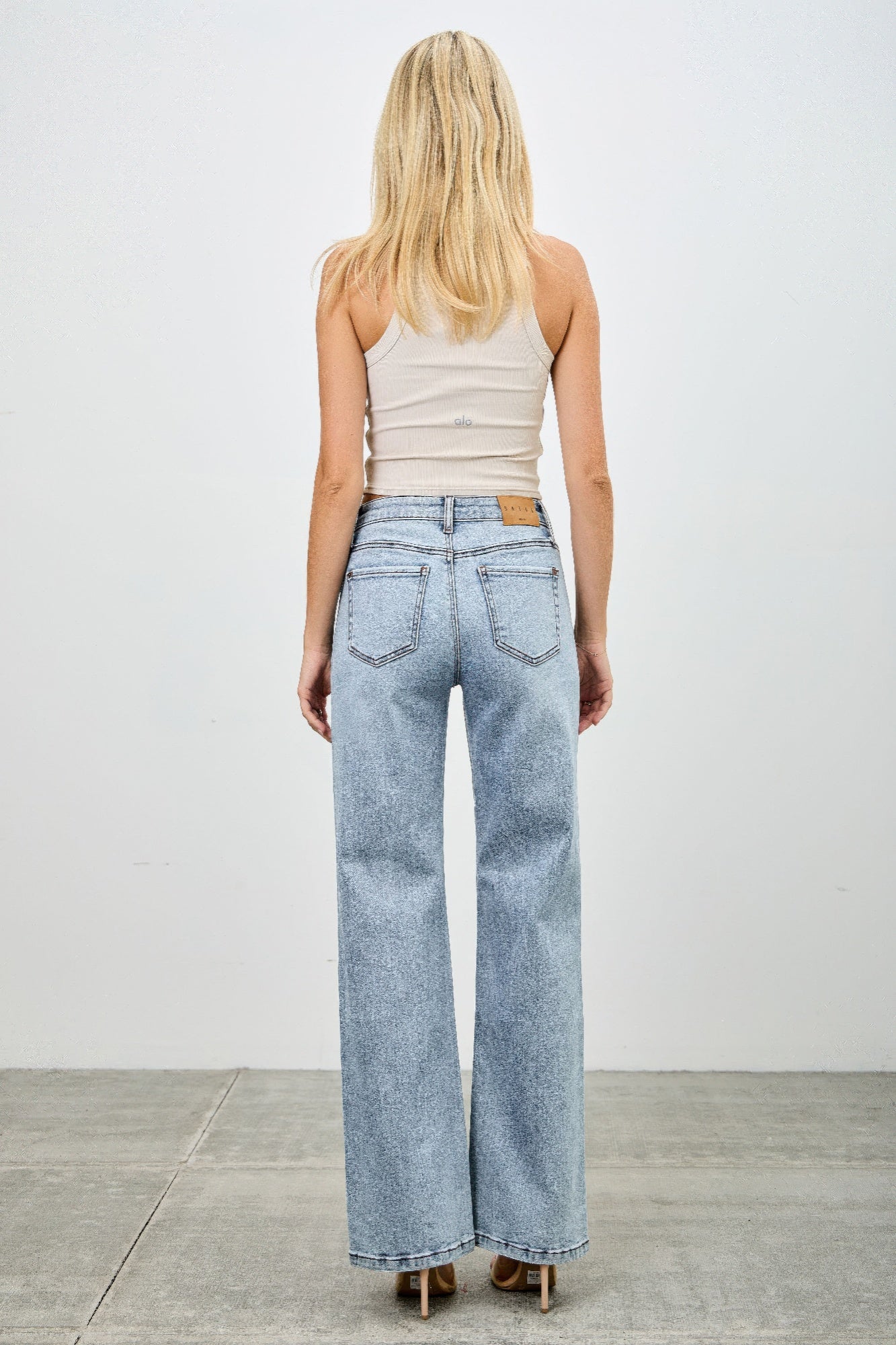 Toshe Women's Fashions mid-rise relaxed straight jeans with distressed hem, front view showing fit and stylish distressed detail.