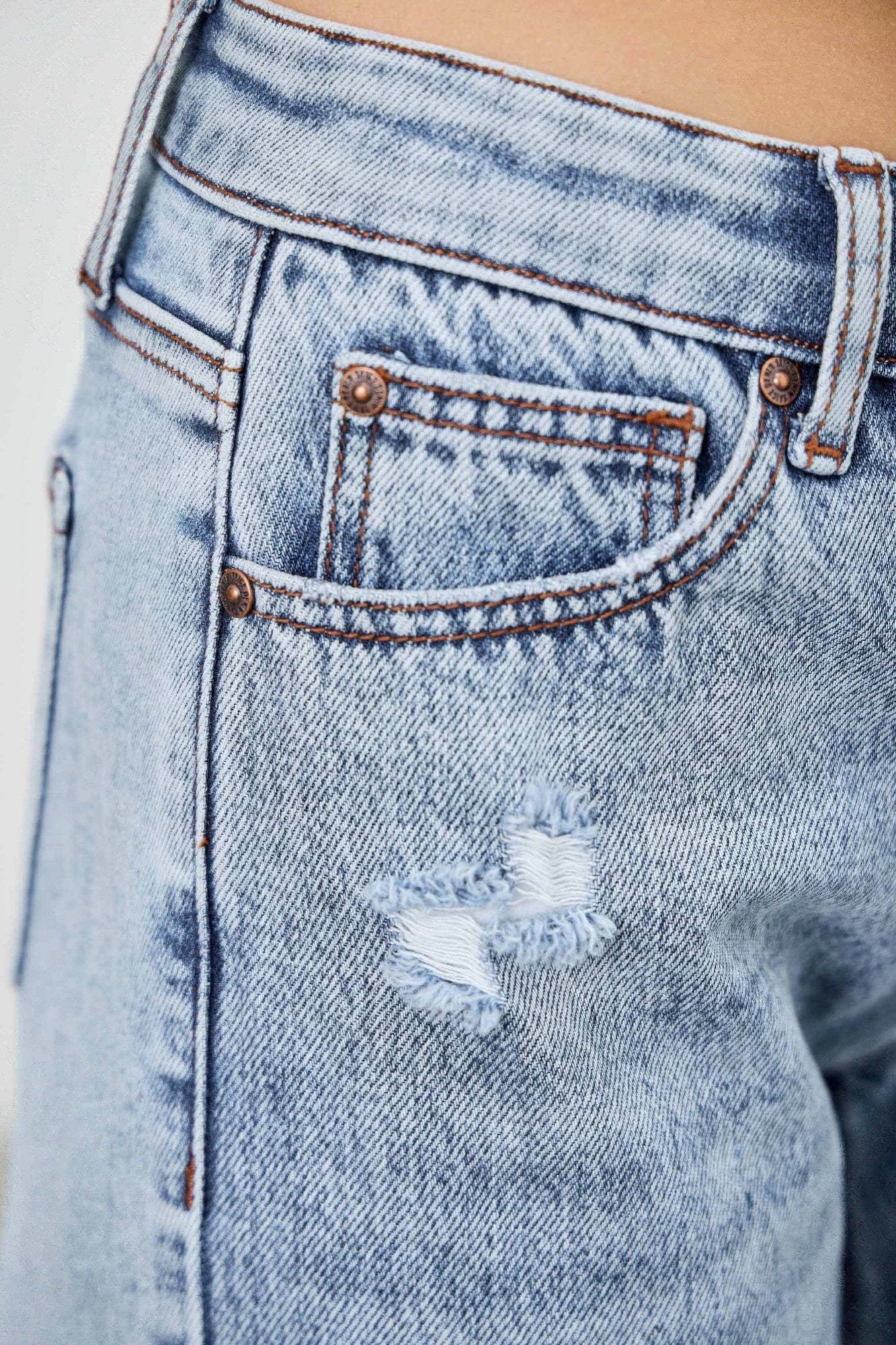 Mid-rise relaxed straight jeans with distressed hem by Toshe Women's Fashions, shown in a casual fit on a model.