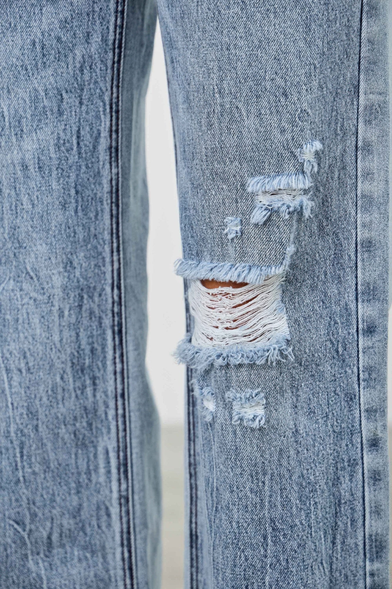 Toshe women's mid-rise relaxed straight jeans with distressed hem, showcasing casual denim fit and stylish distressed details.