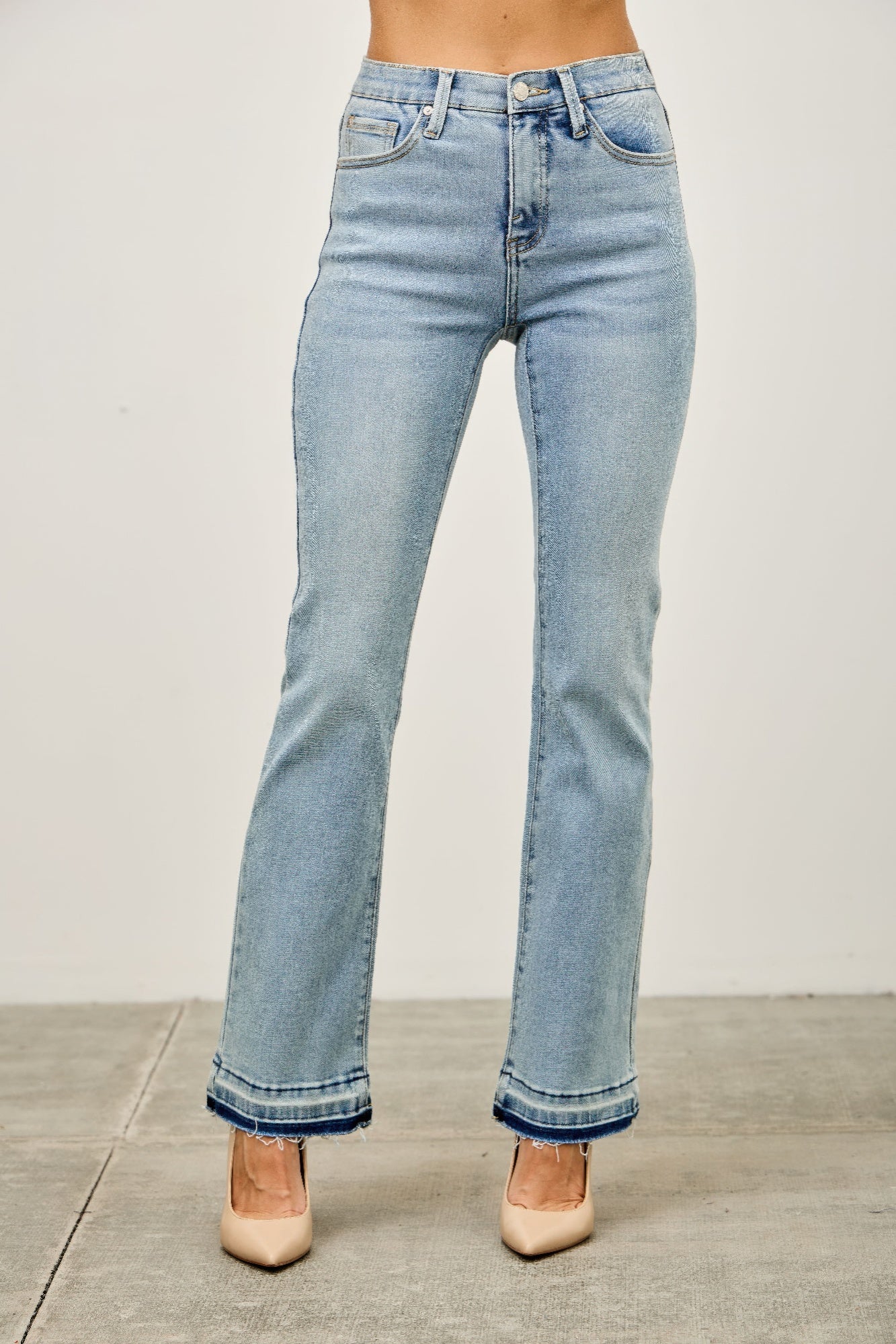 Mid-rise flare jeans with released hem from Toshe Women's Fashions, shown with a focus on the stylish fit and hem detail.