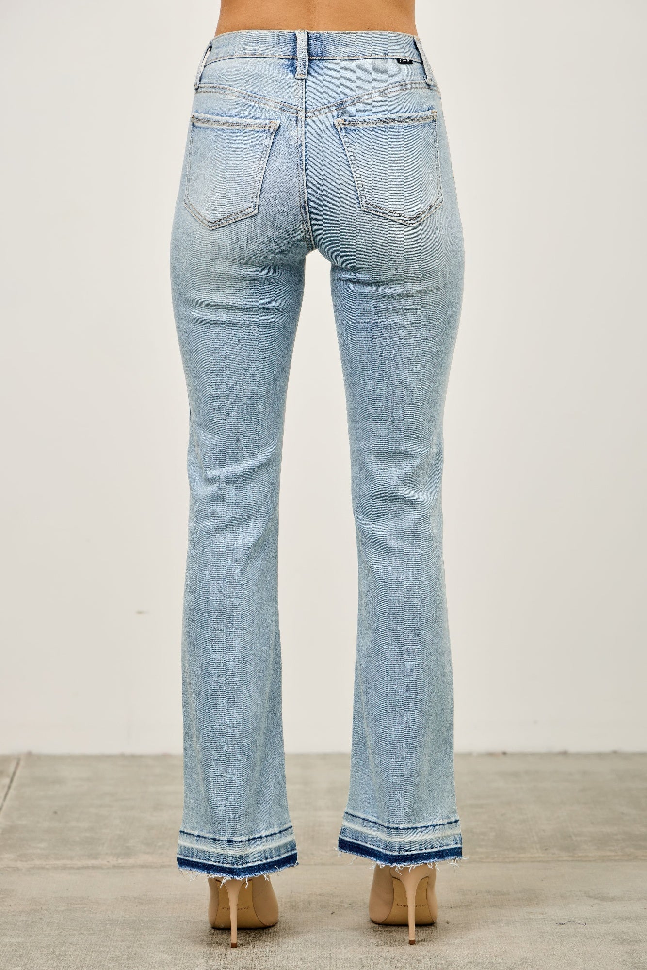 Mid rise flare jeans with released hem from Toshe Women's Fashions, shown in dark denim with stylish distressed details.